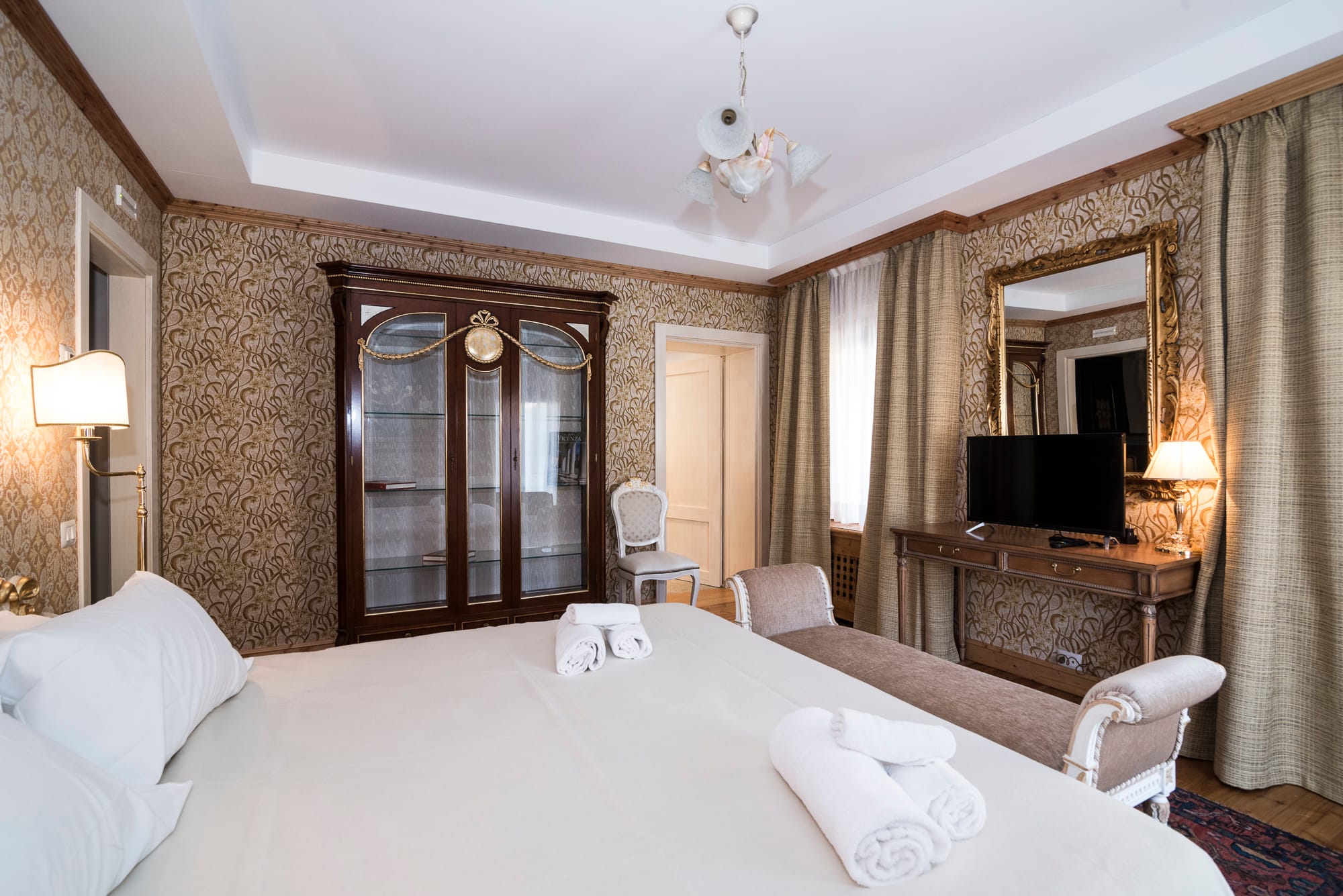 a large hotel room with a large bed and a large mirror