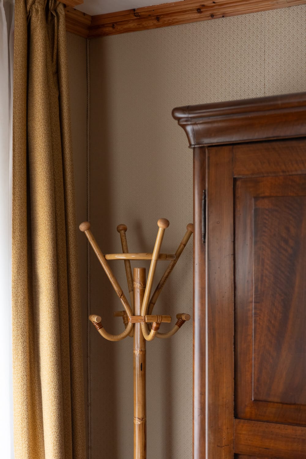 a wooden coat rack next to a cabinet