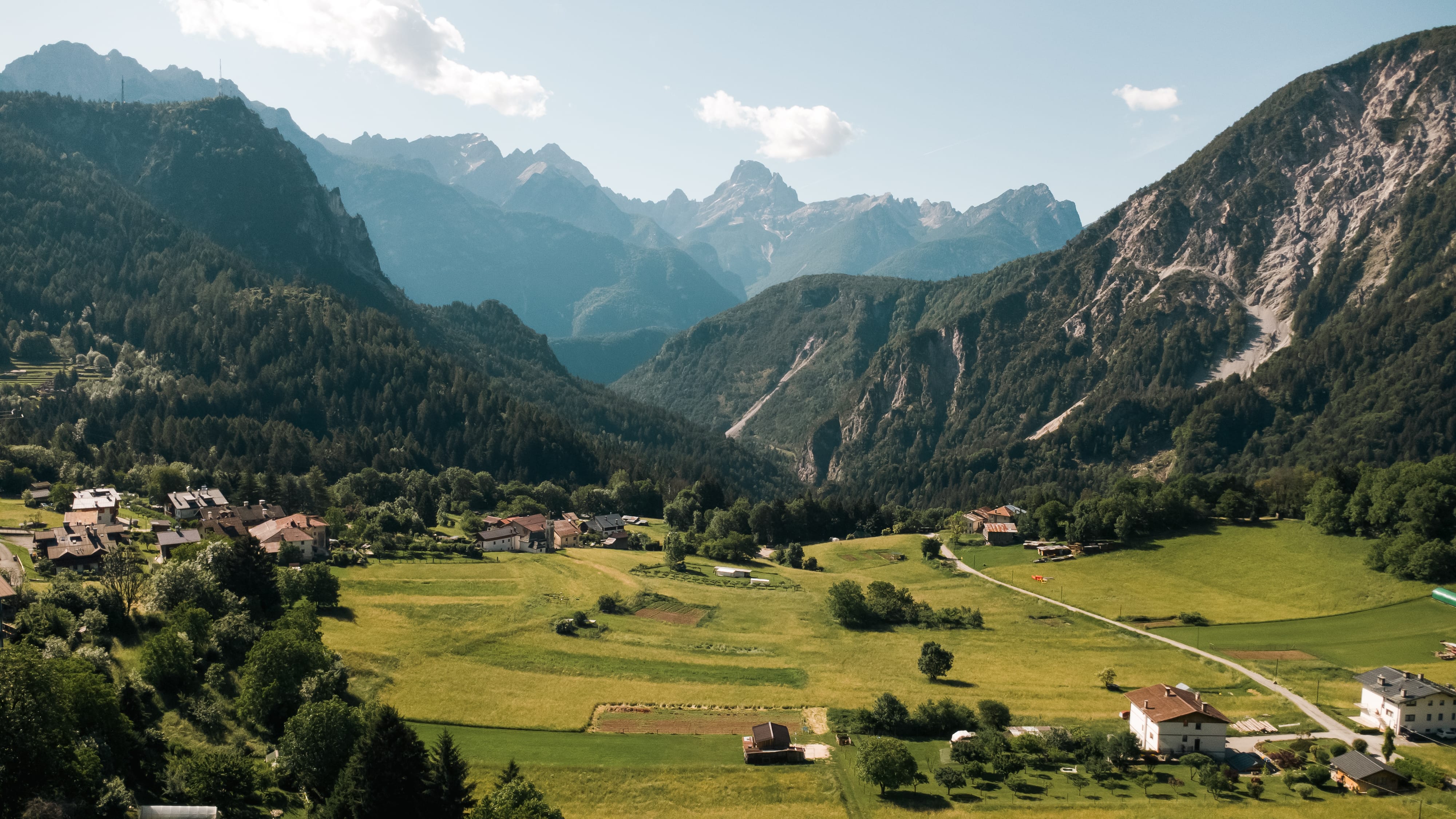 a green valley with mountains in the background