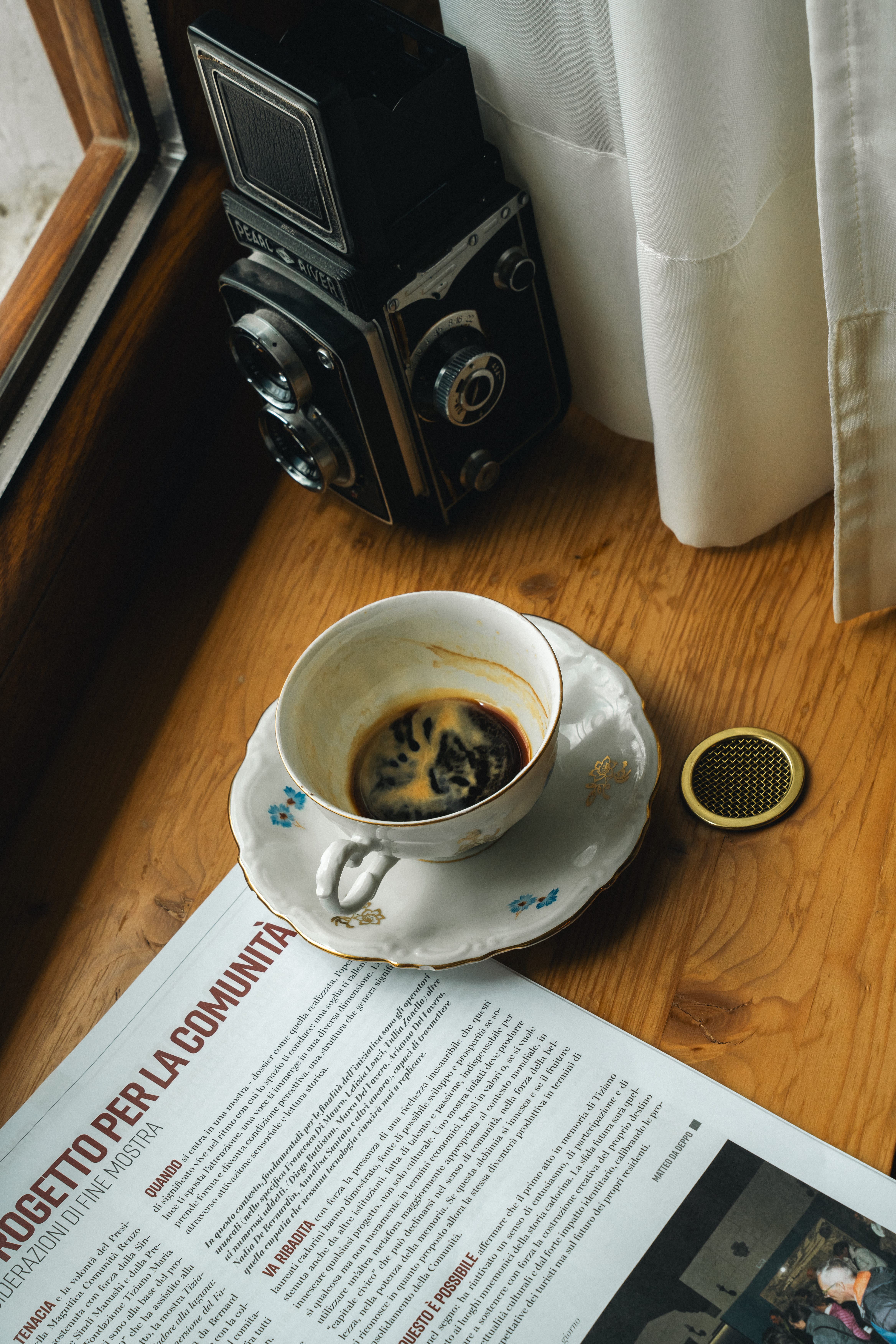 a cup of coffee and a camera on a table