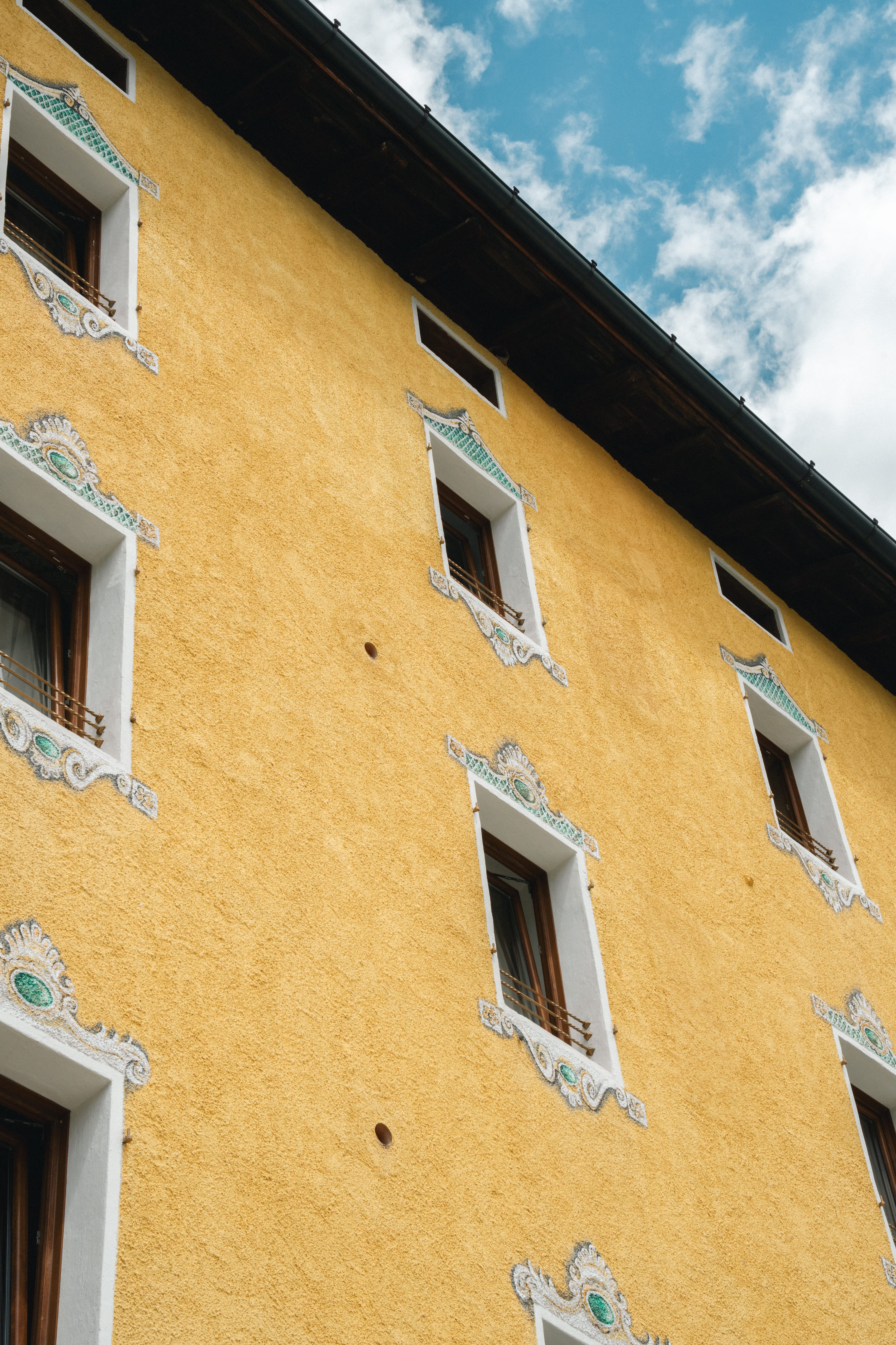 a yellow building with persony windows
