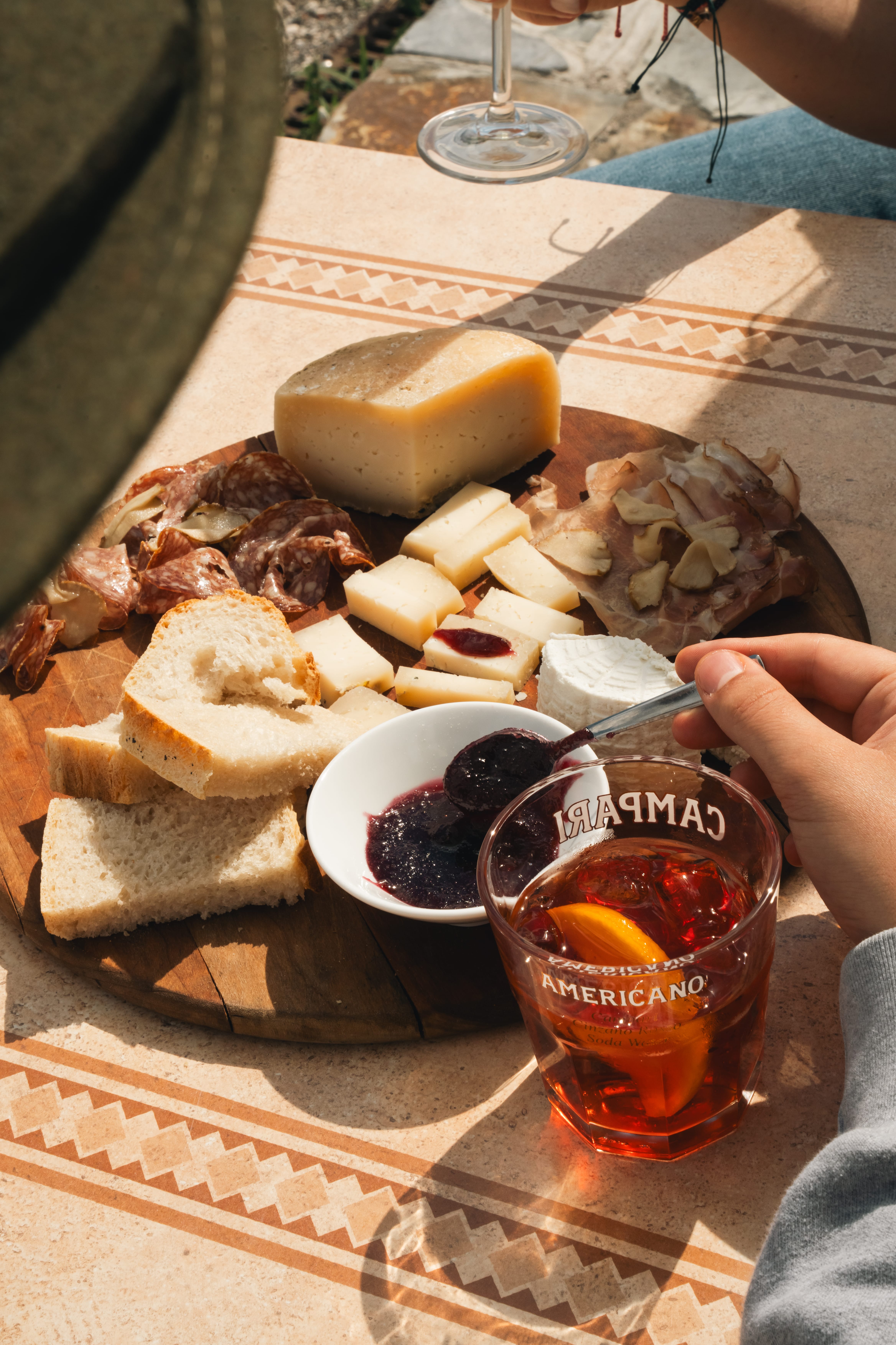 a person eating cheese and bread on a wooden board