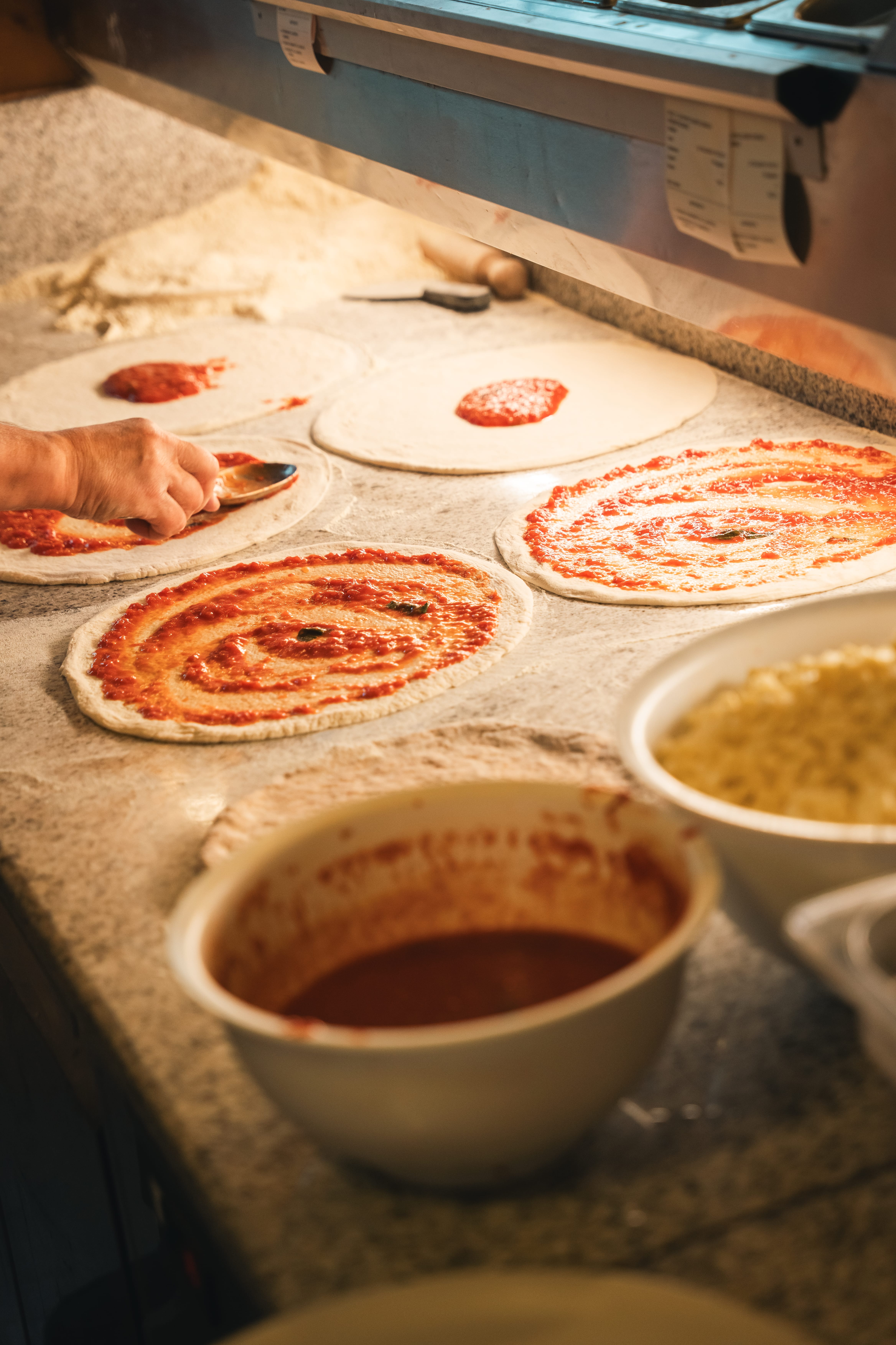 a person making pizza on a counter
