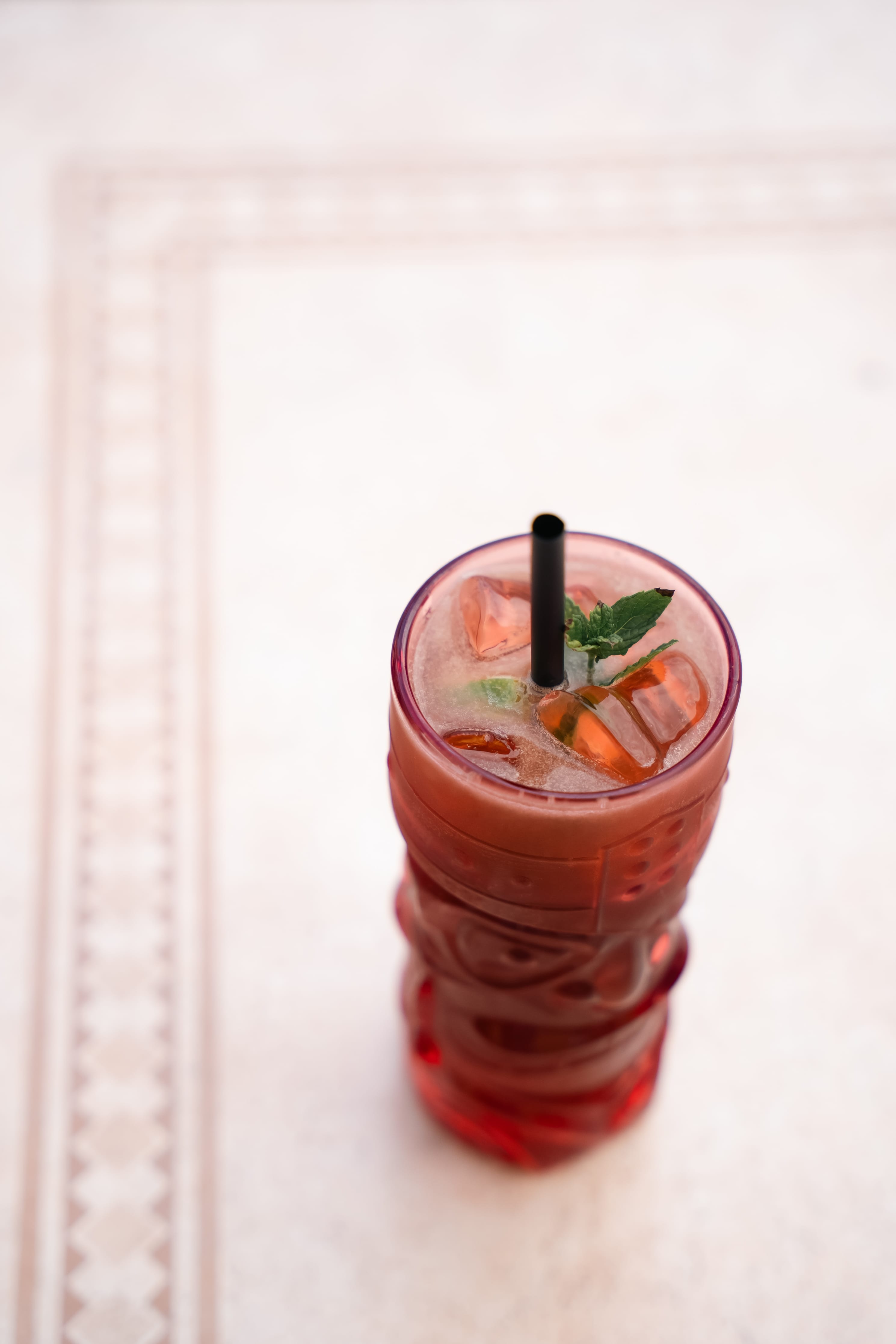 a glass of liquid with ice and a straw