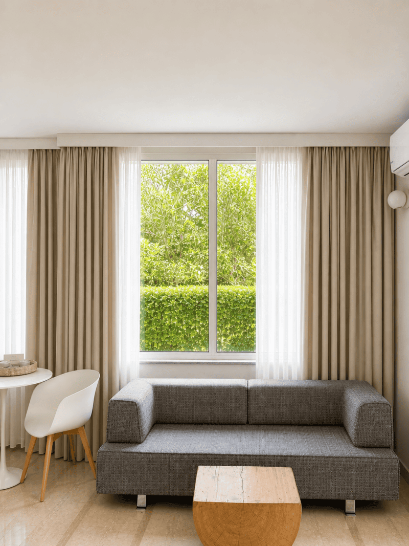 a room with a couch and a table and a air conditioner