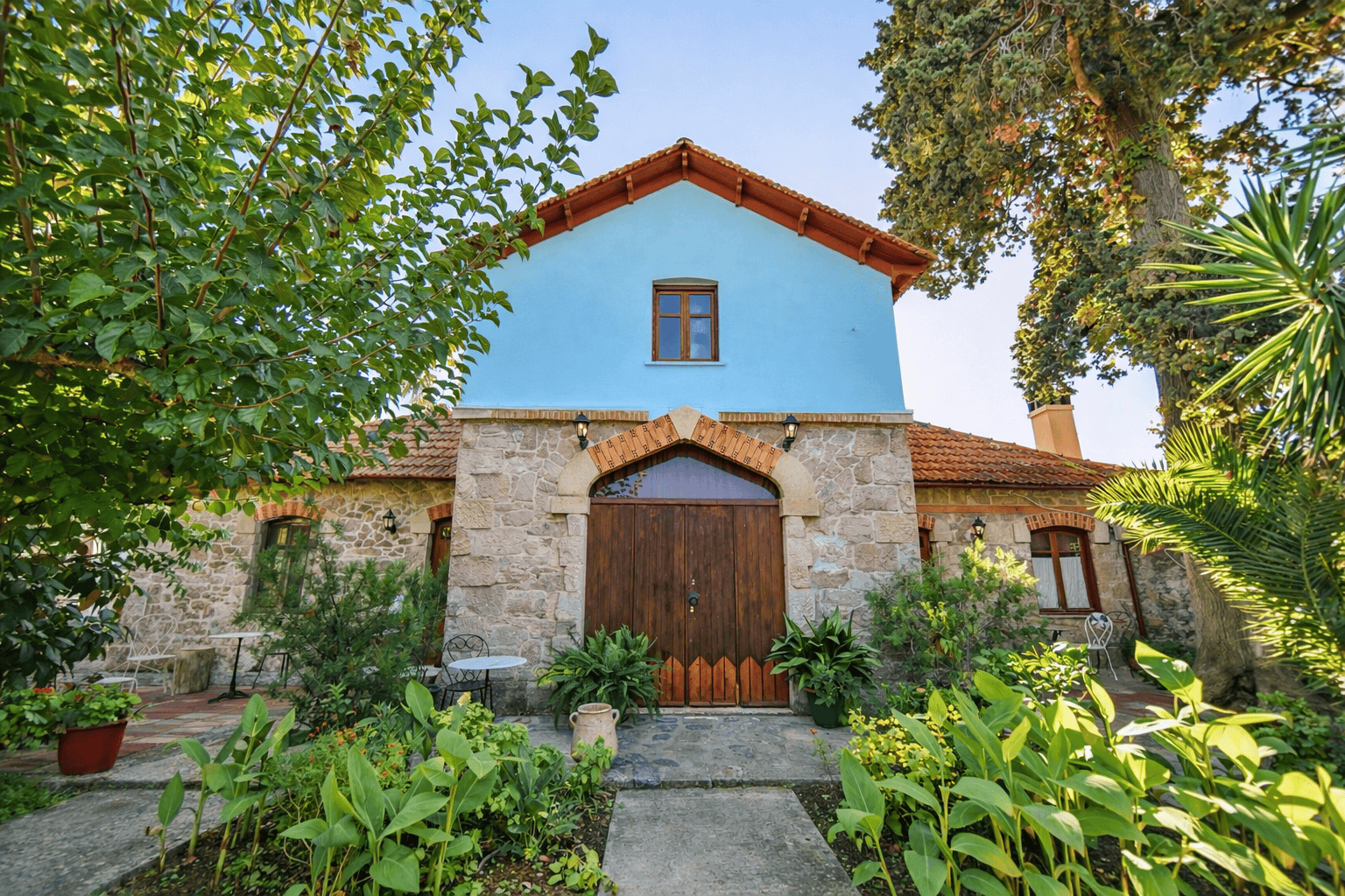 a house with a blue door and a stone wall