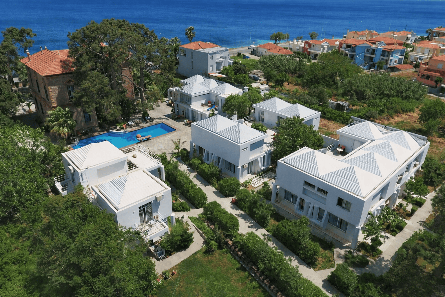 a group of houses with a pool in front of the water