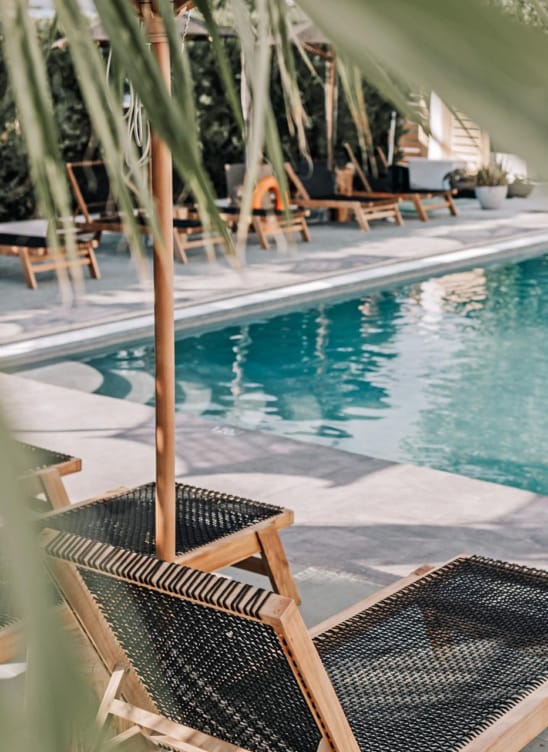 a pool with a deck and chairs