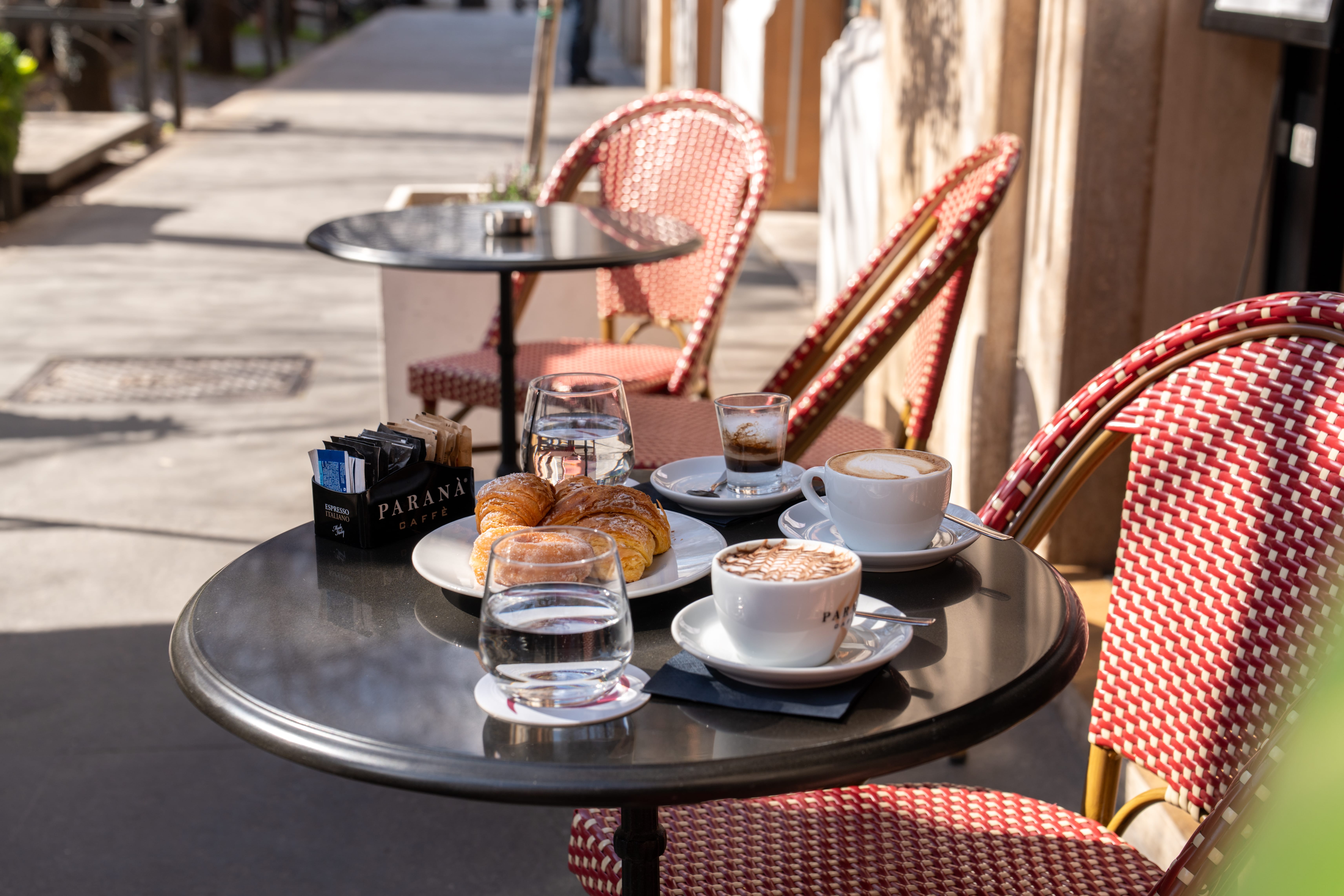 a table with a tray of food and cups of coffee