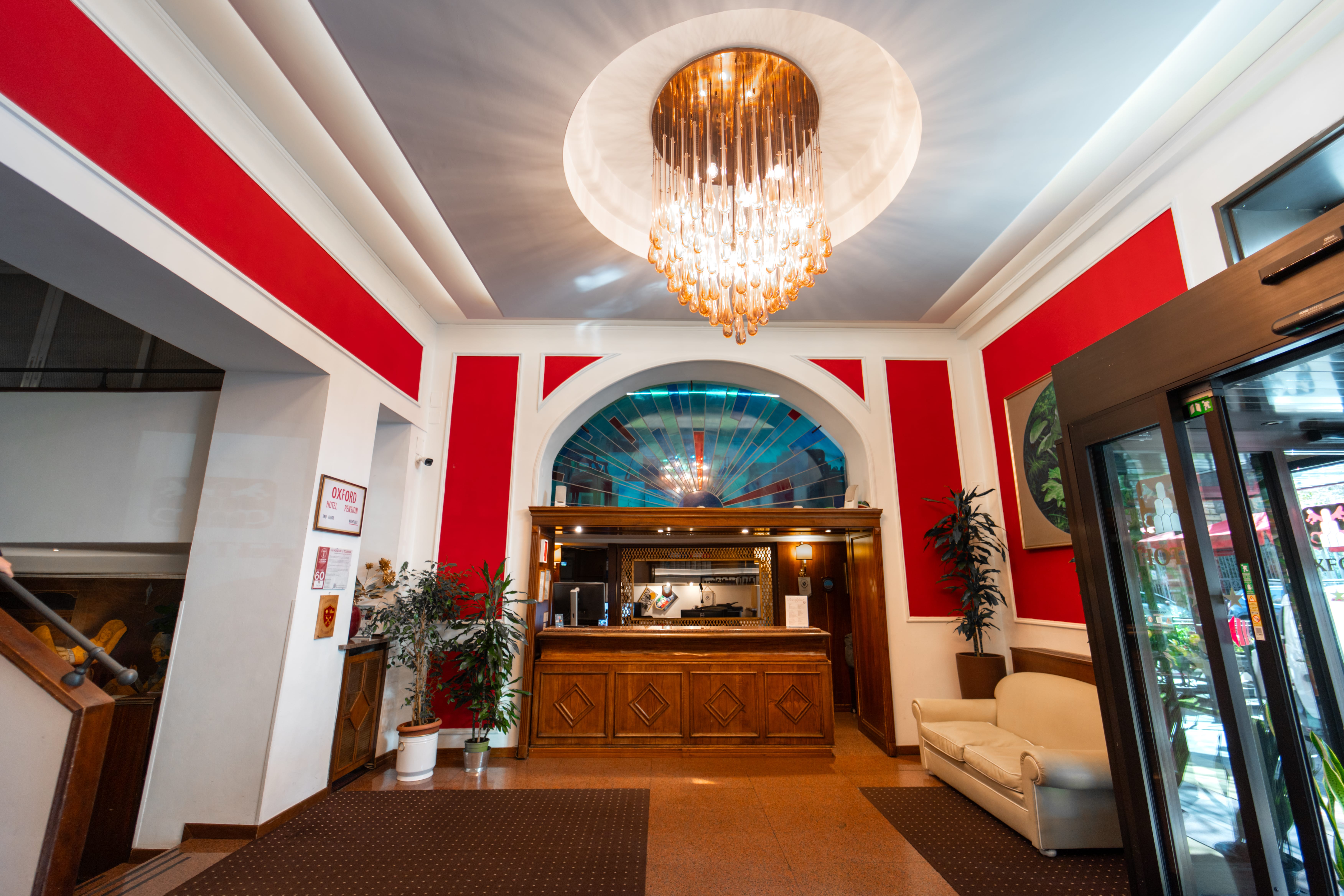 a room with a large chandelier and a wood cabinet