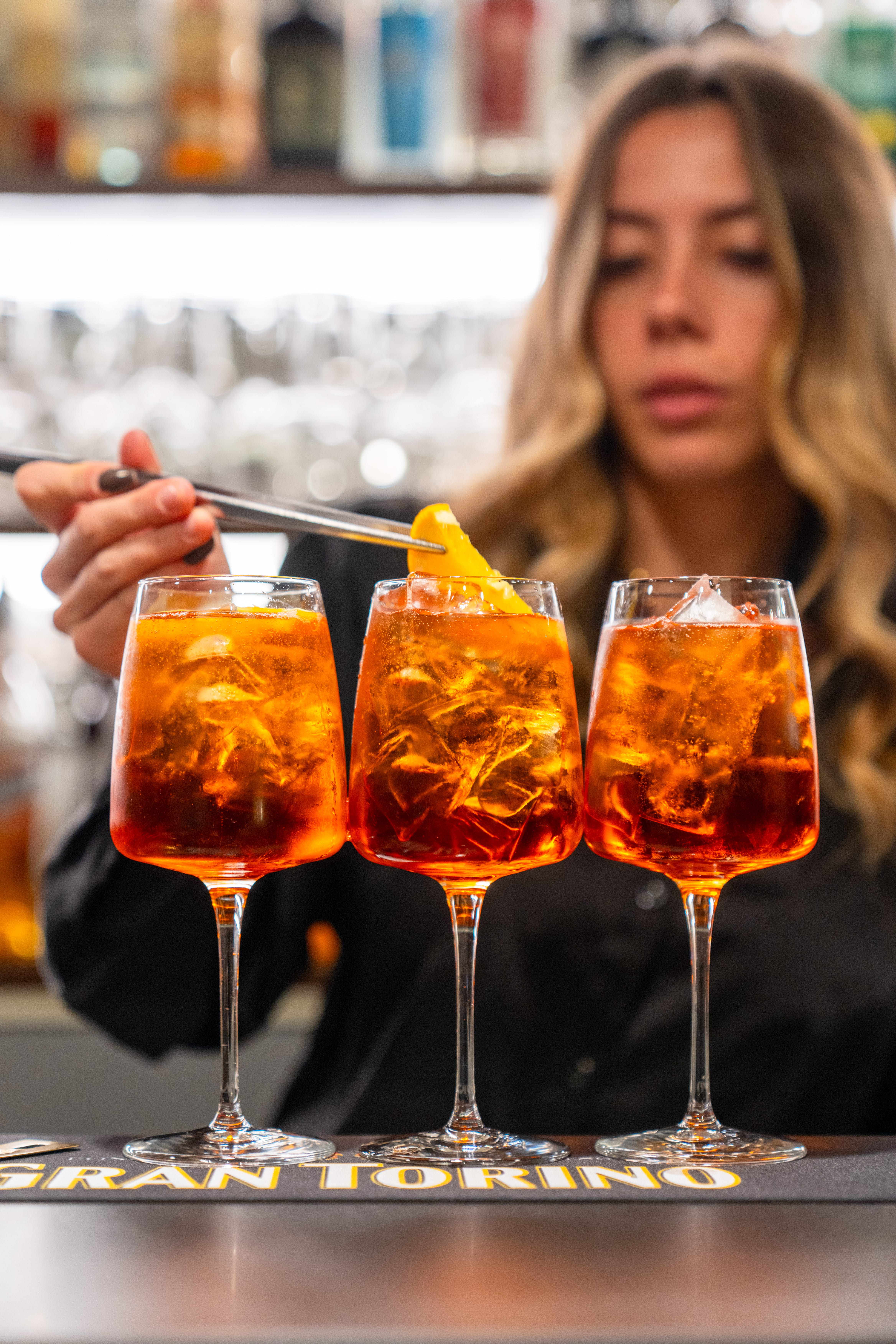 a person holding a fork and a group of glasses with liquid in them