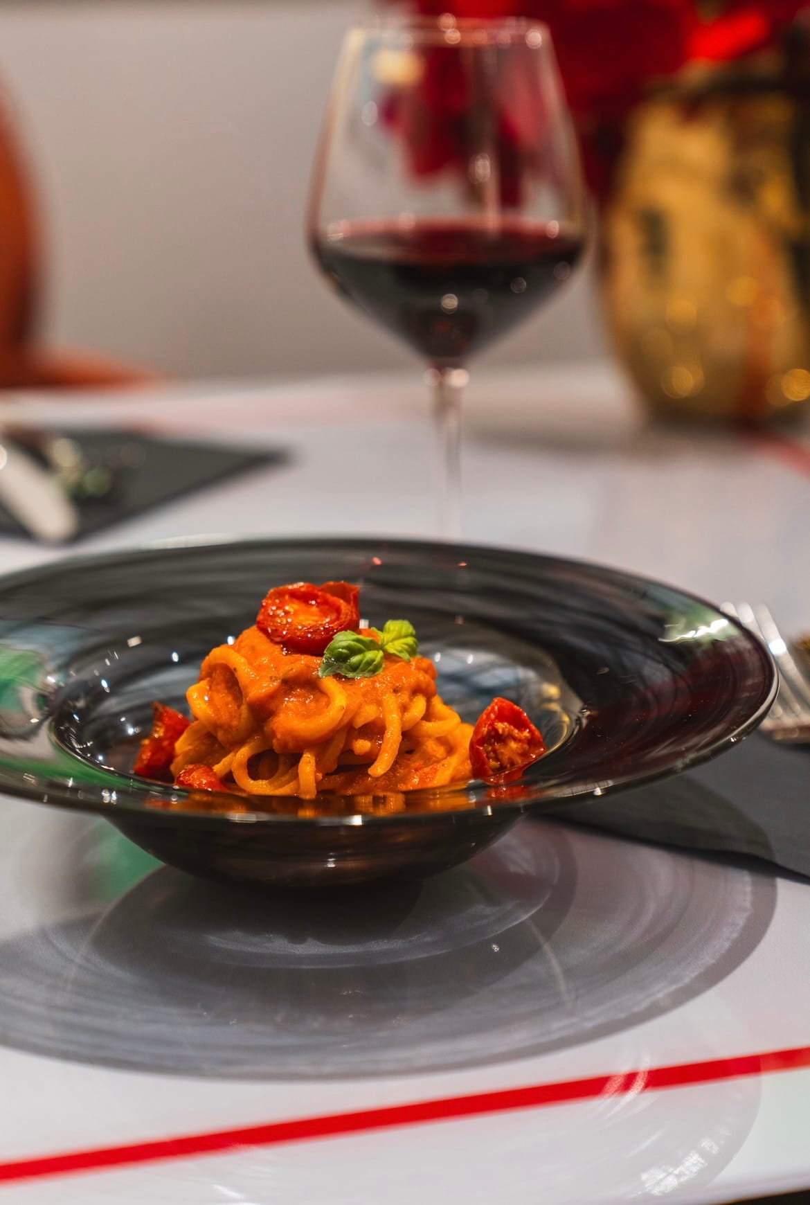 a bowl of food next to a glass of wine