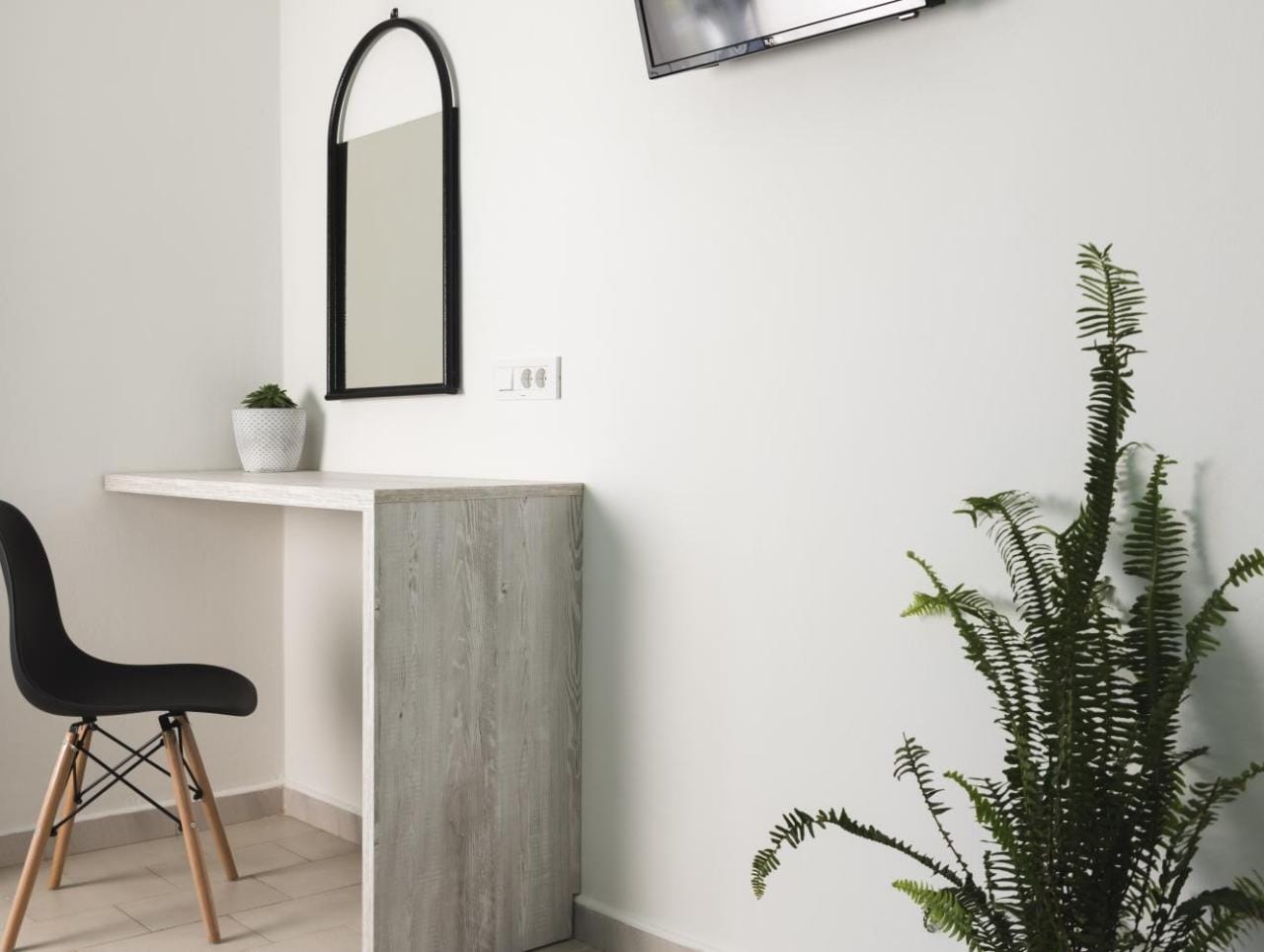 a white desk with a mirror and a plant