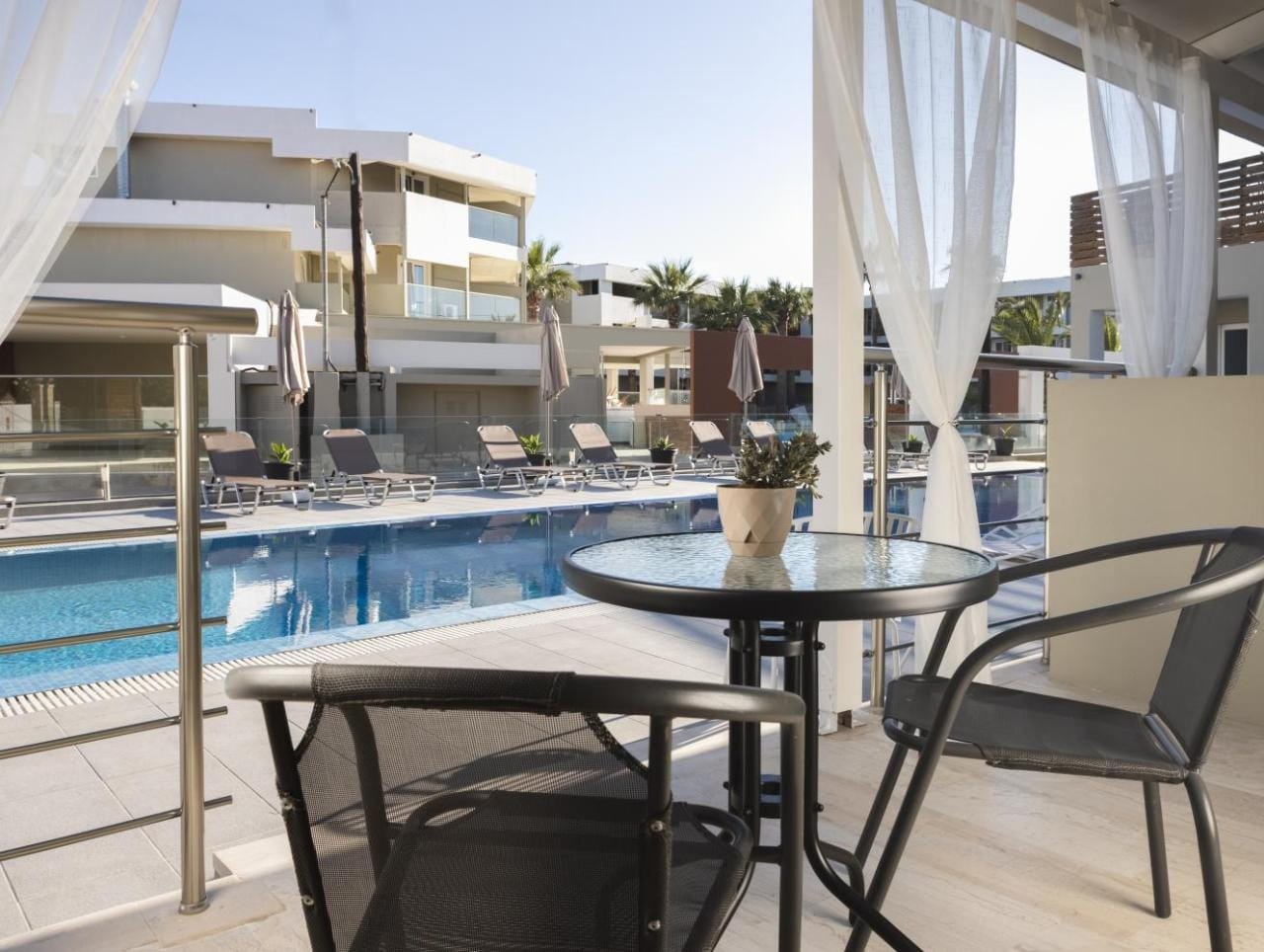 a pool and chairs next to a swimming pool