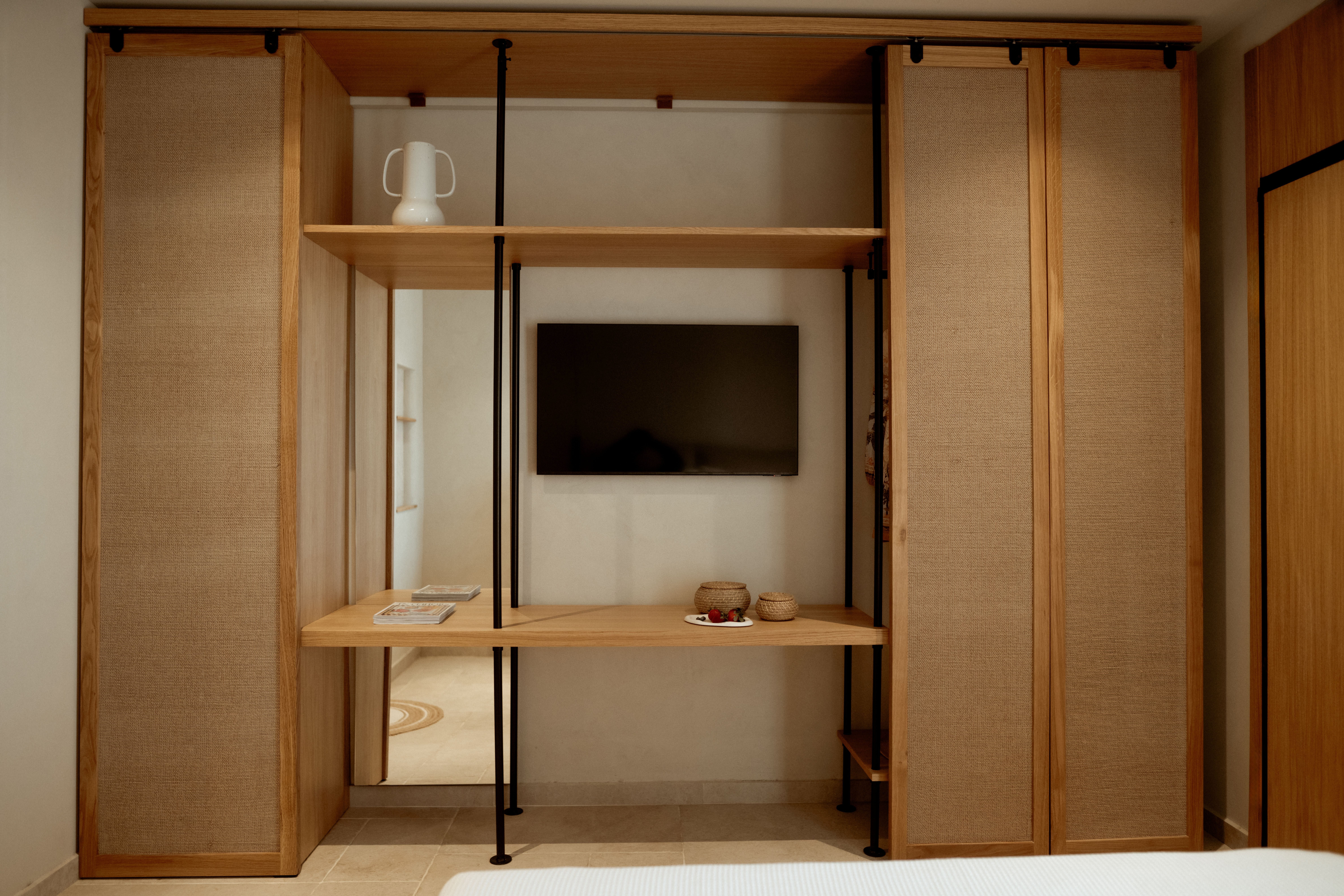 a room with a tv and shelves