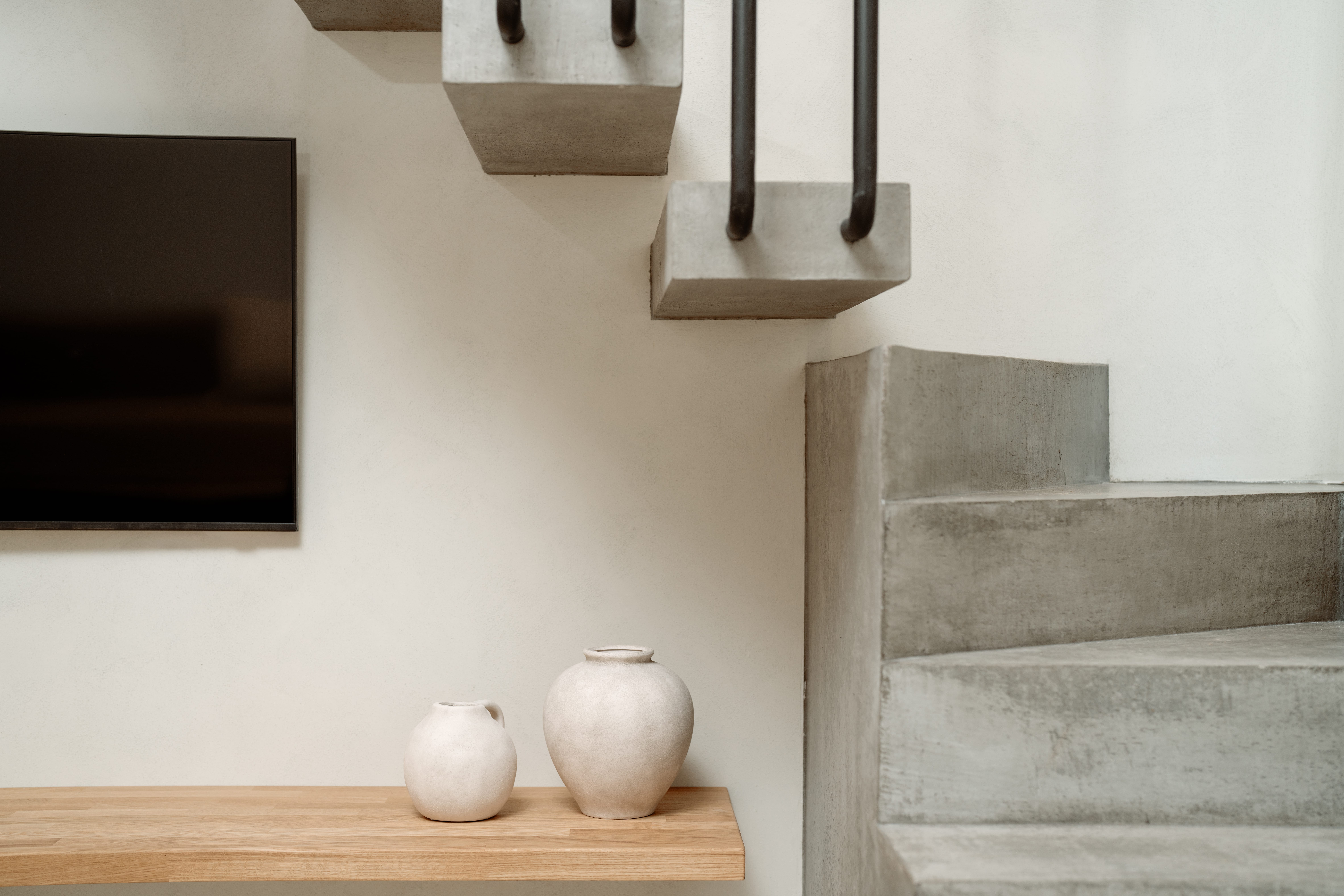 a couple of white vases on a shelf