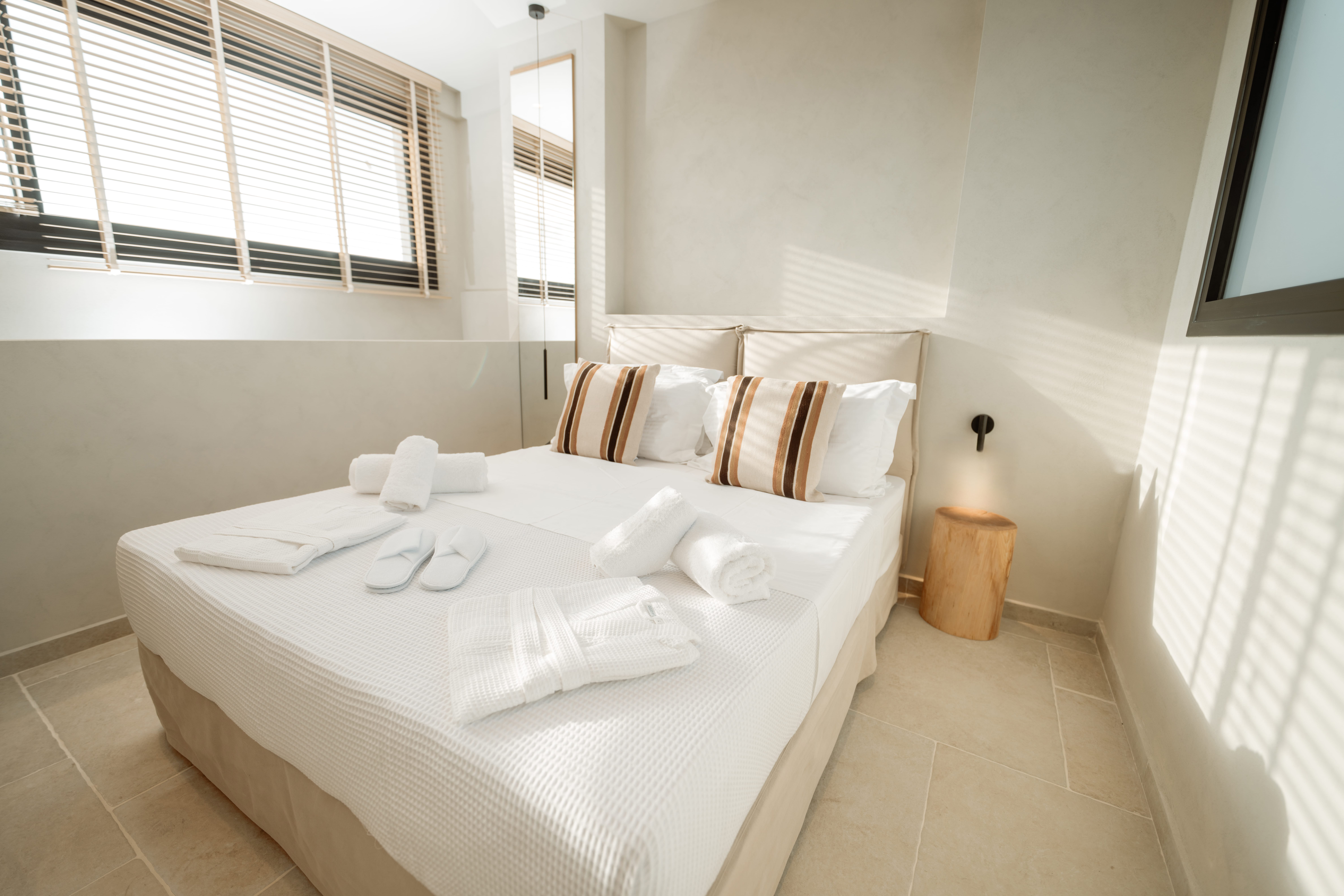 a bed with a white sheet and white towels on it