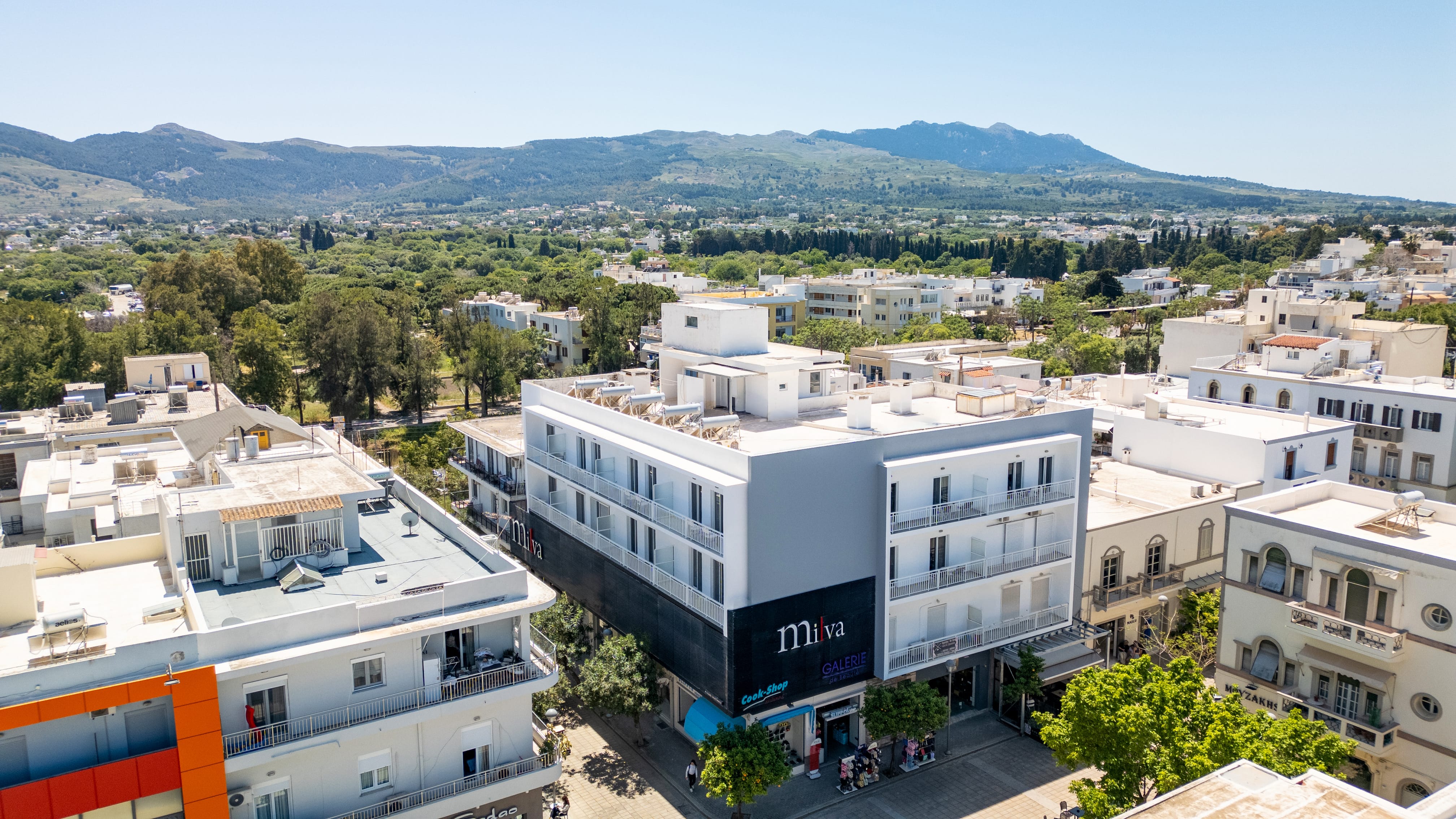 a building with trees and mountains in the background