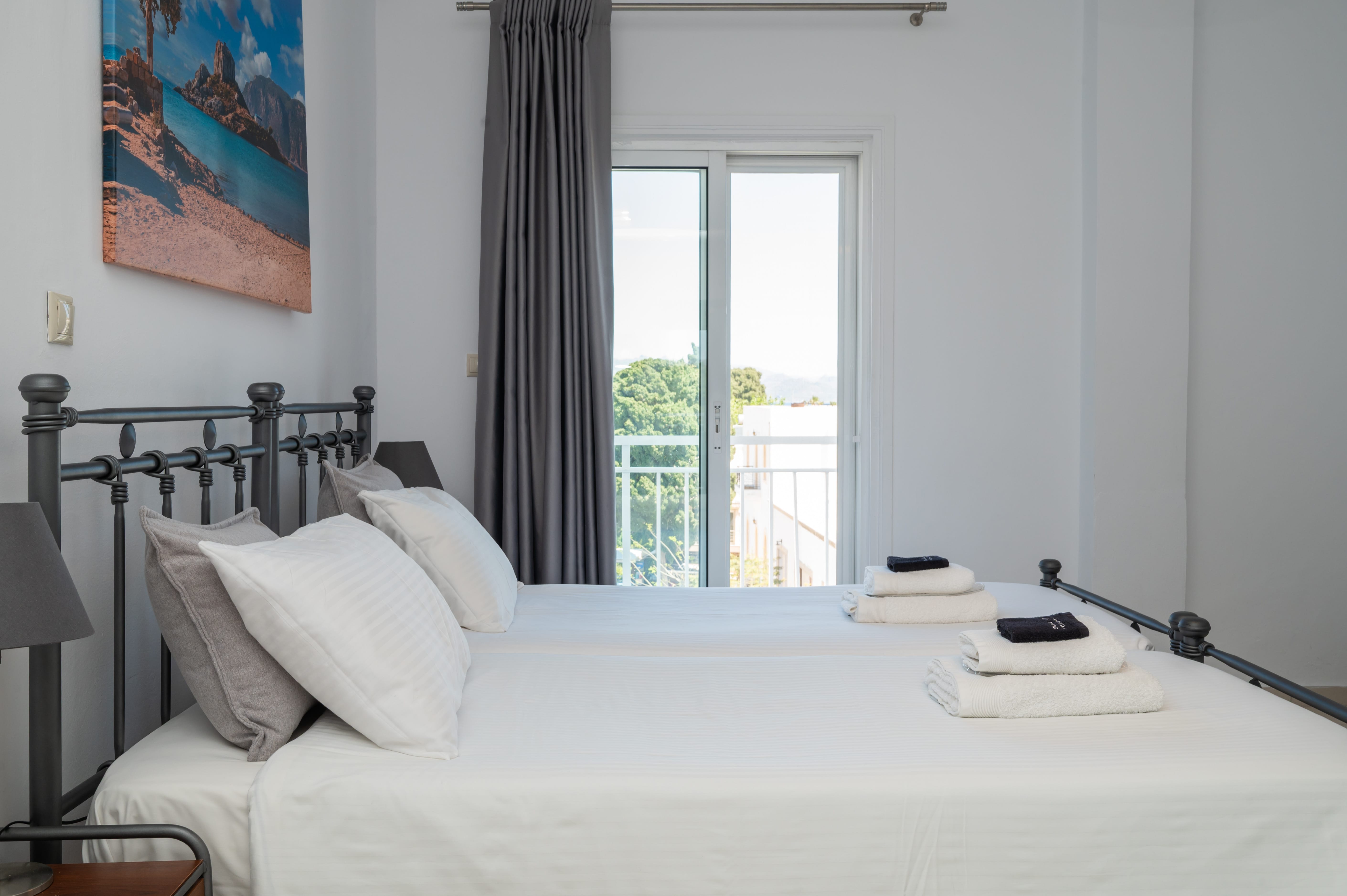 a bed with white sheets and towels