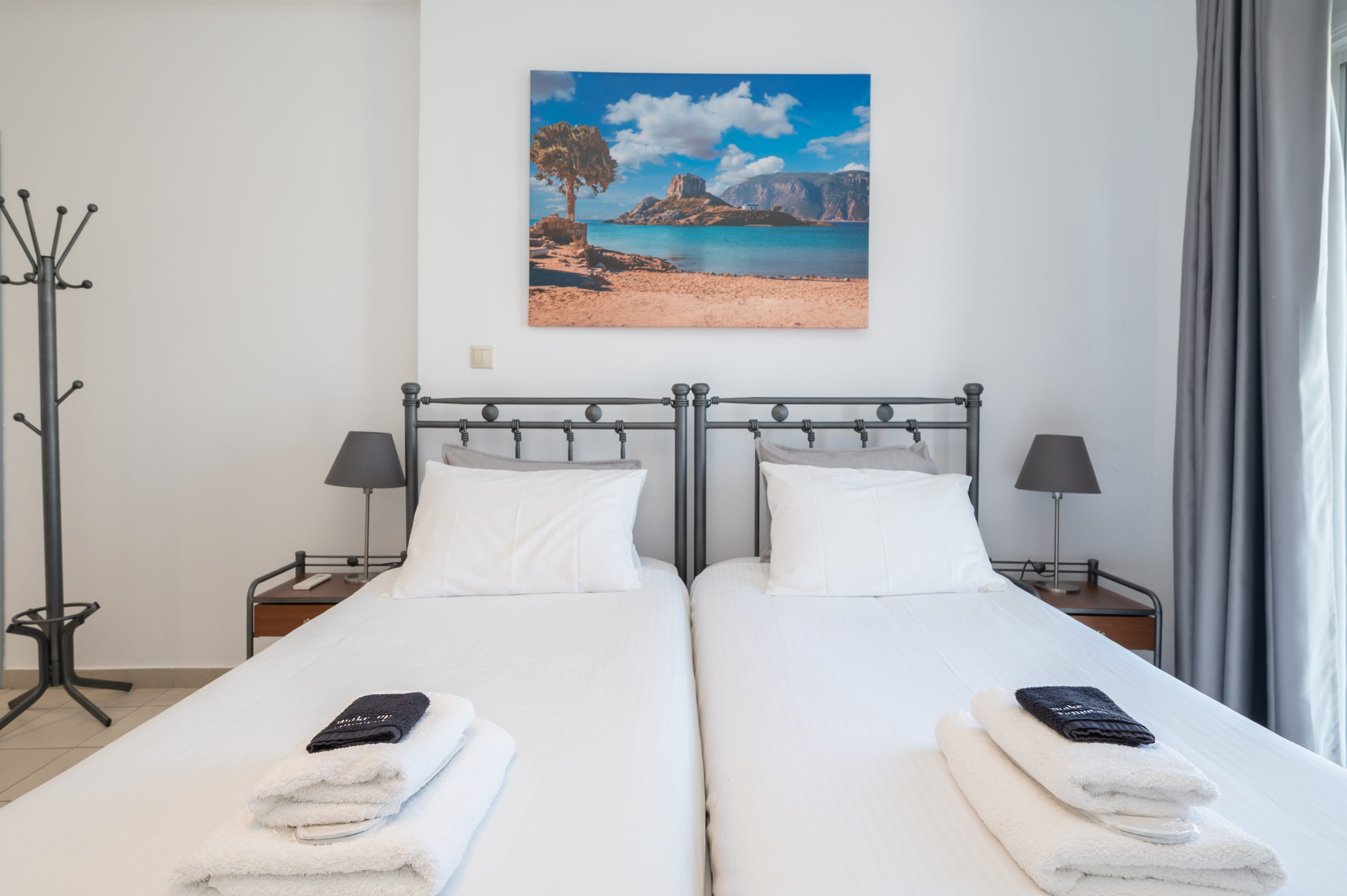 a bed with white sheets and towels on it