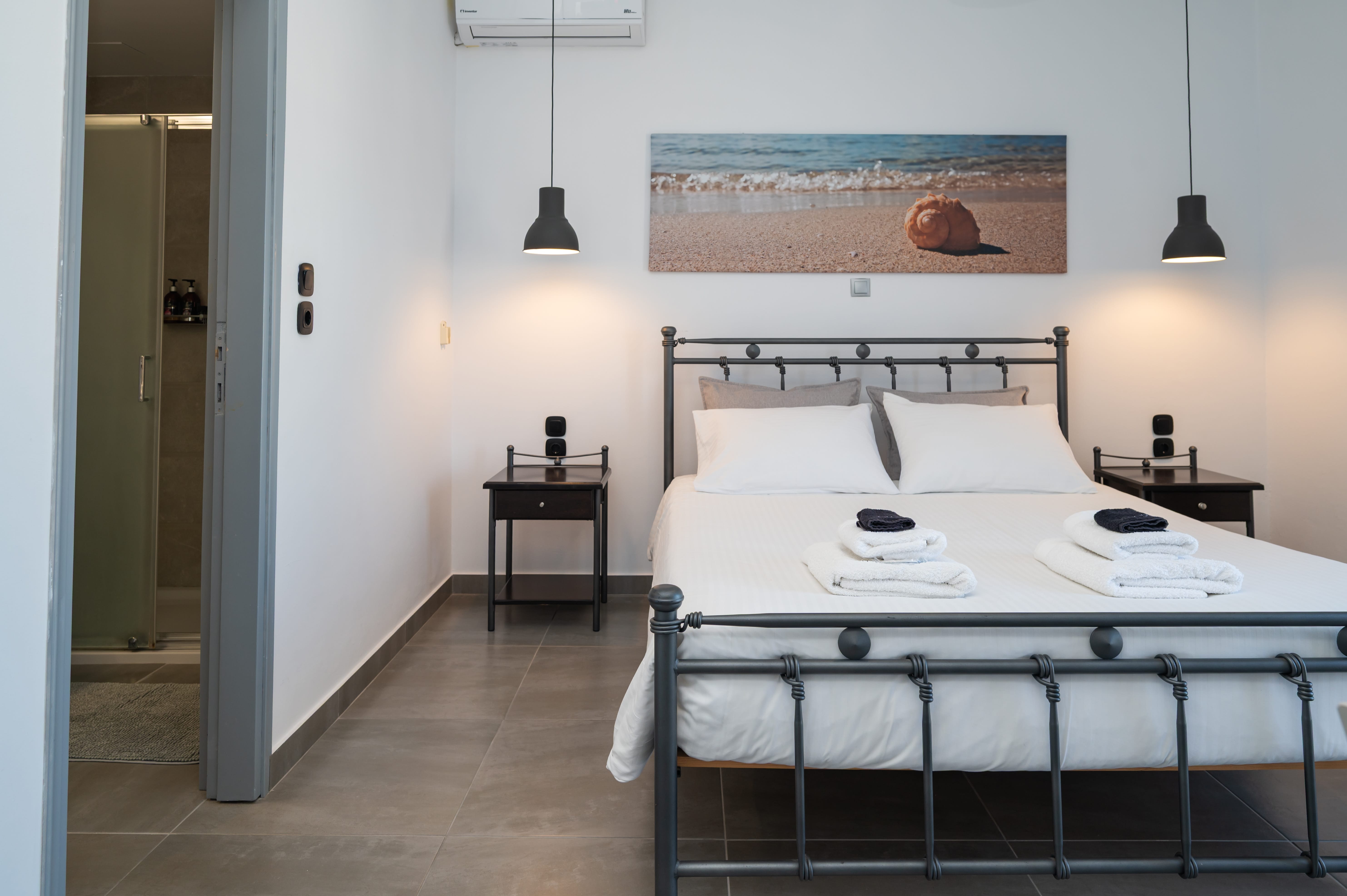 a bed with white sheets and a black metal frame