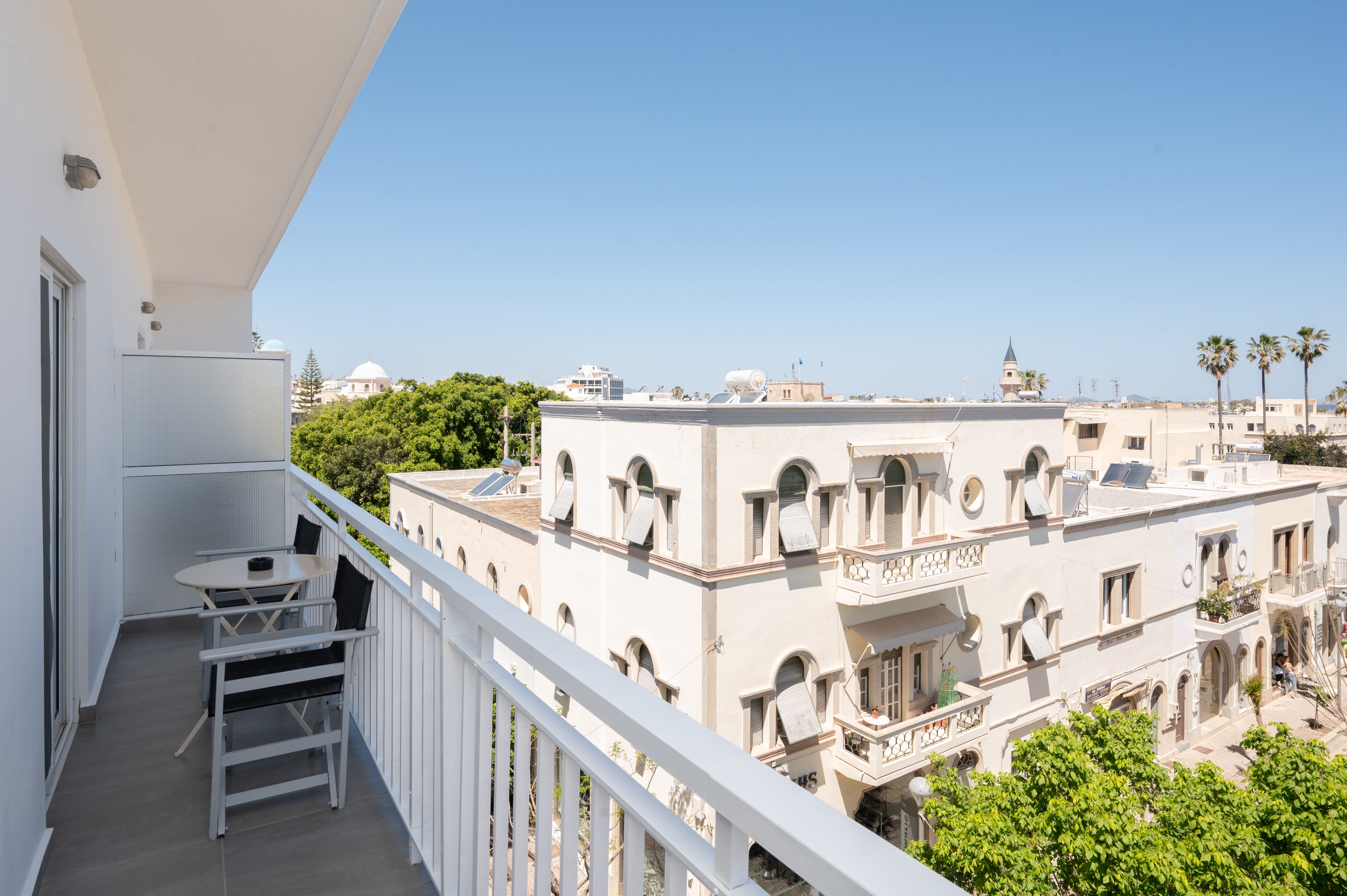 a balcony with a white railing and a white building