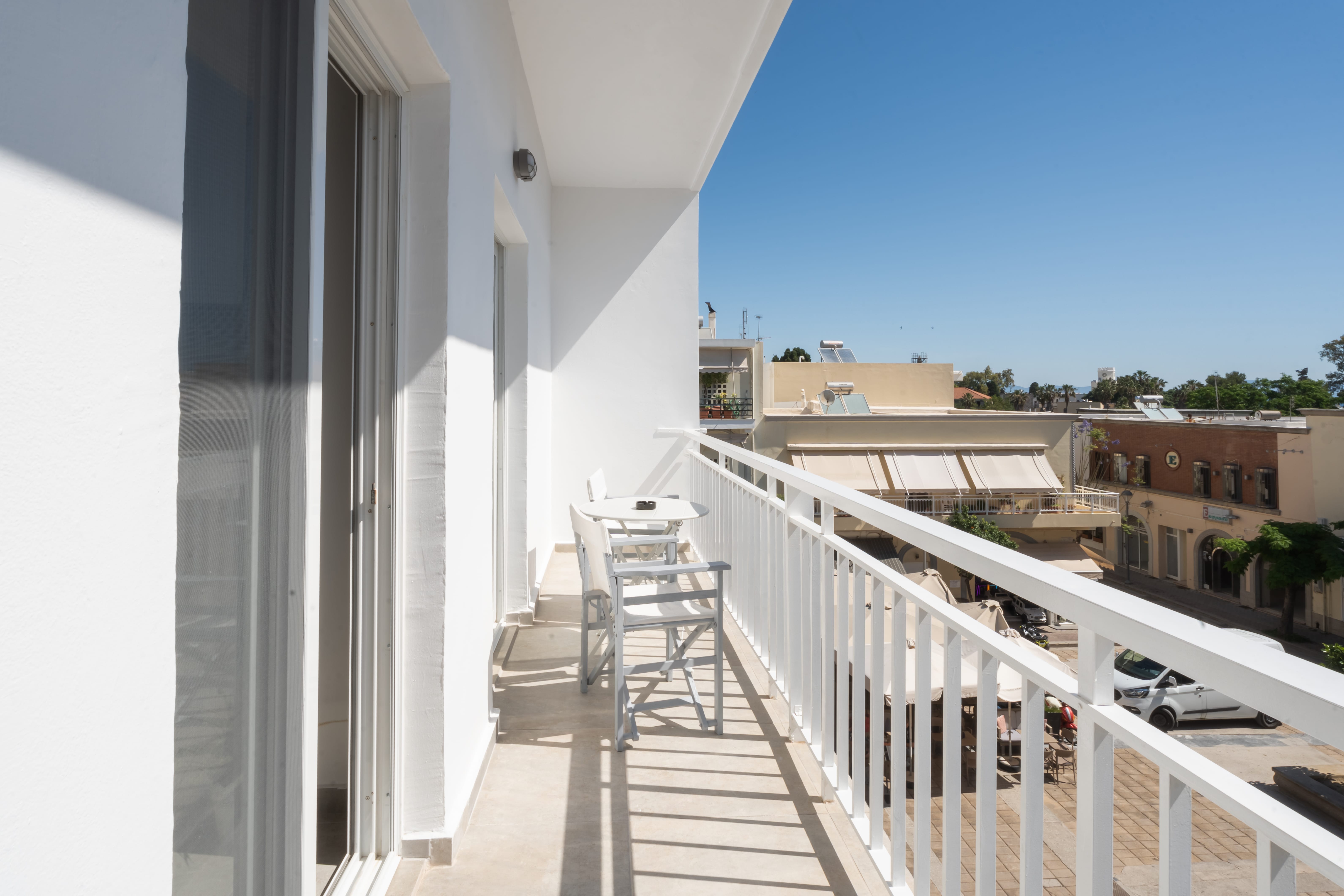 a white balcony with chairs and a table