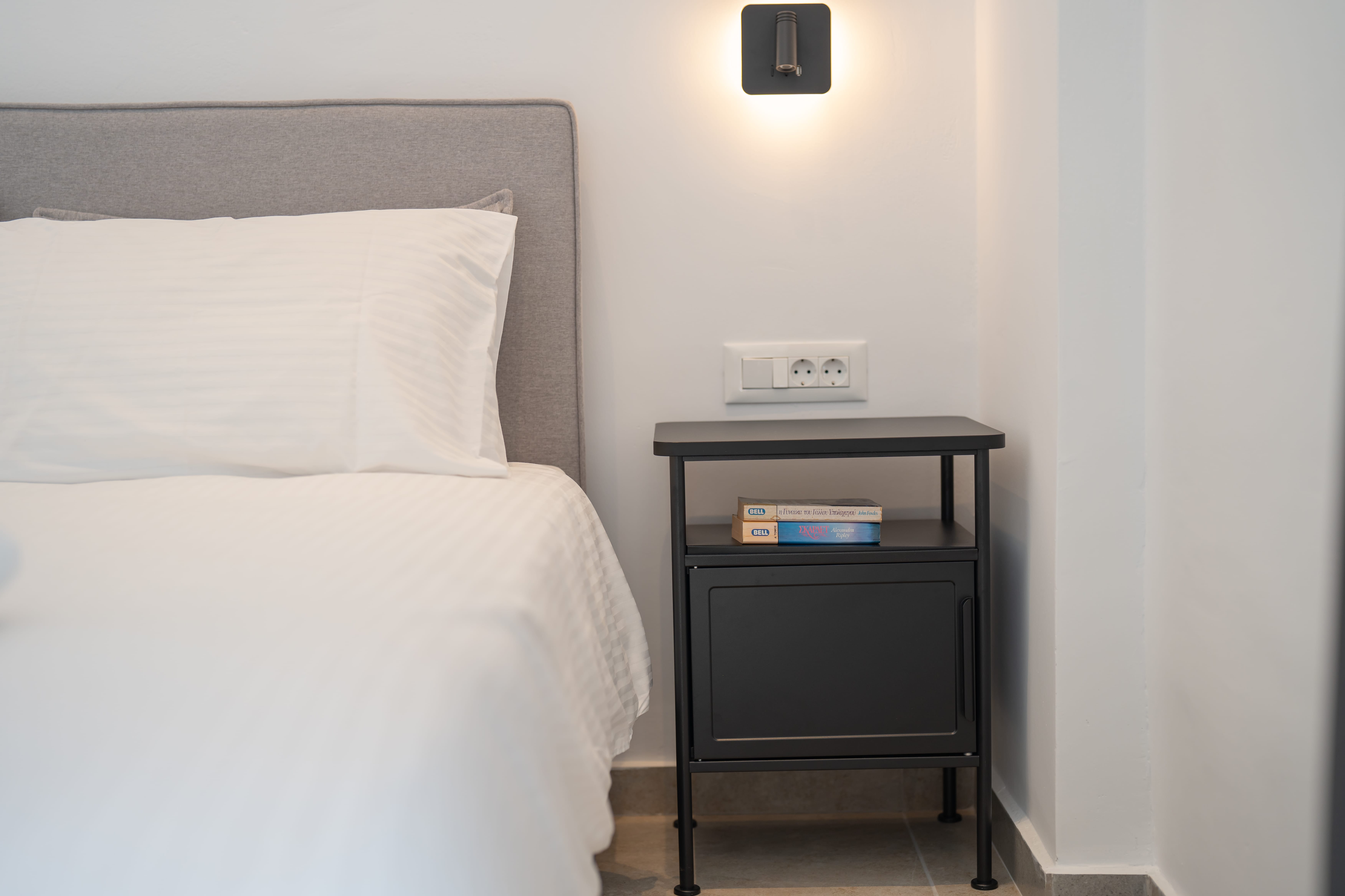 a bed with a white bedding and a black night stand