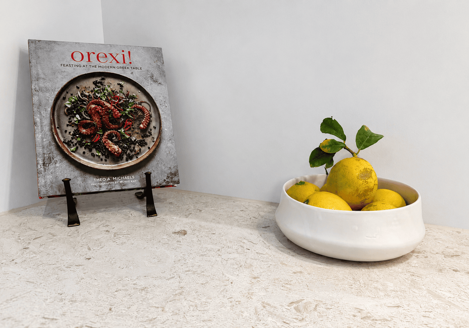 a bowl of fruit next to a picture of a plant