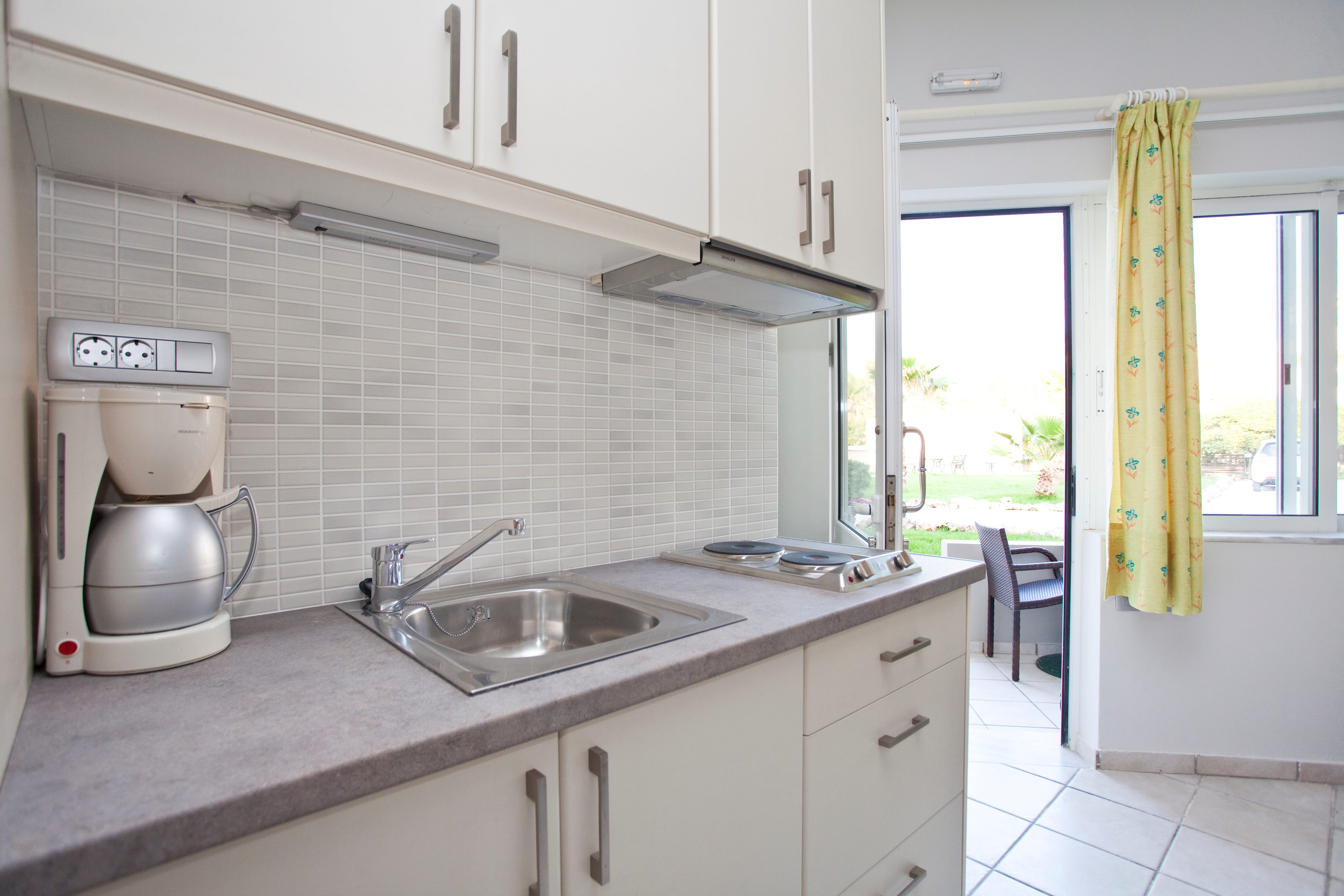 a kitchen with a sink and a coffee maker