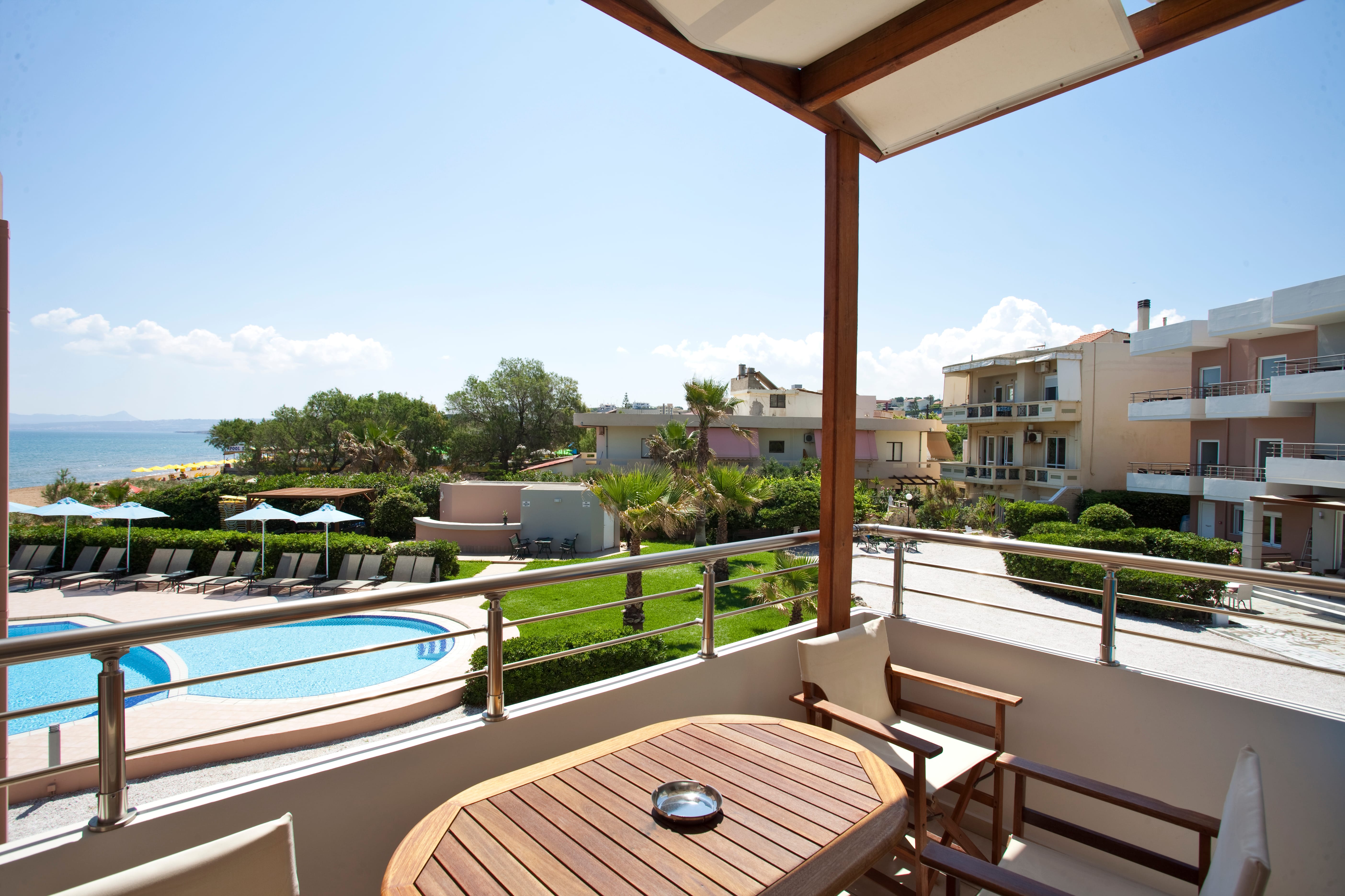 a deck with a table and chairs and a pool and buildings