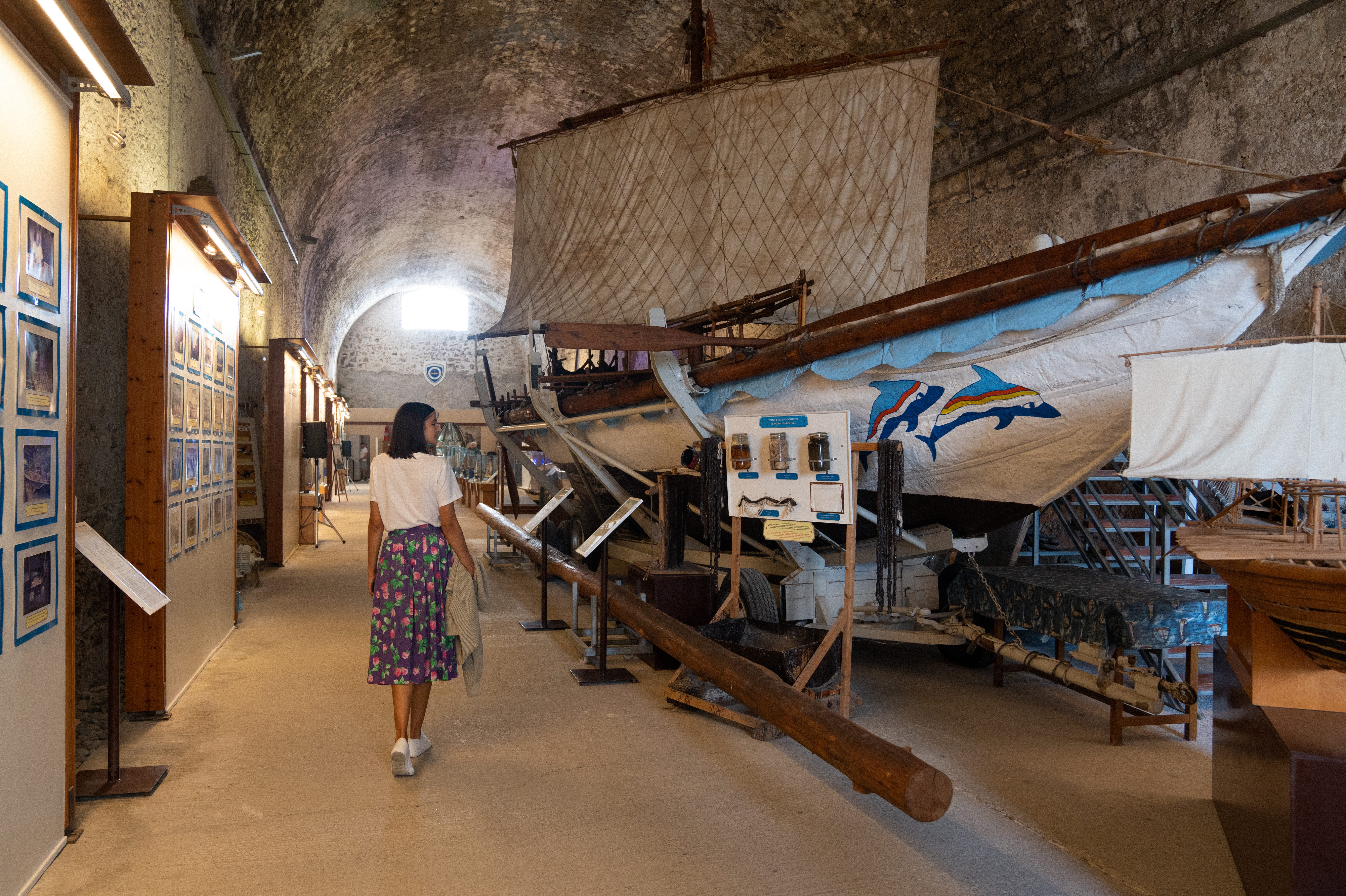 a person walking in a room with a large wooden boat