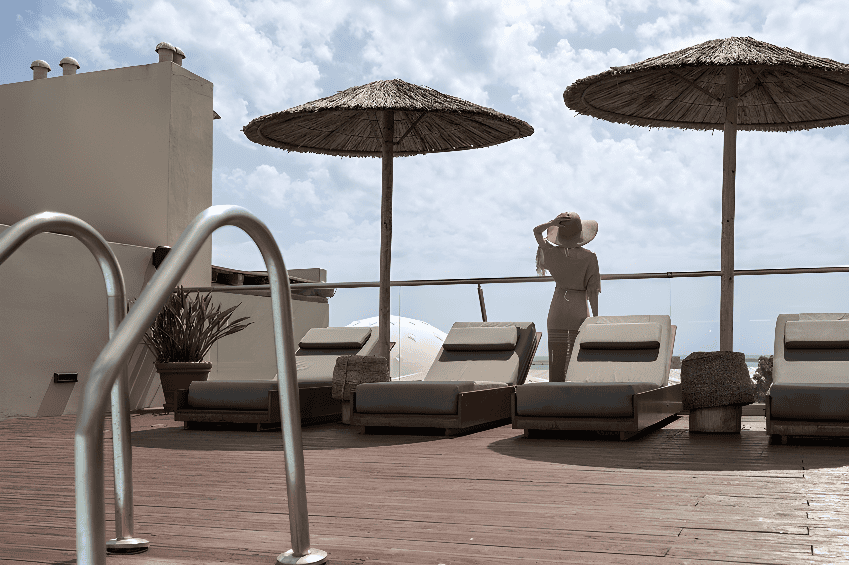 a person standing on a deck with umbrellas