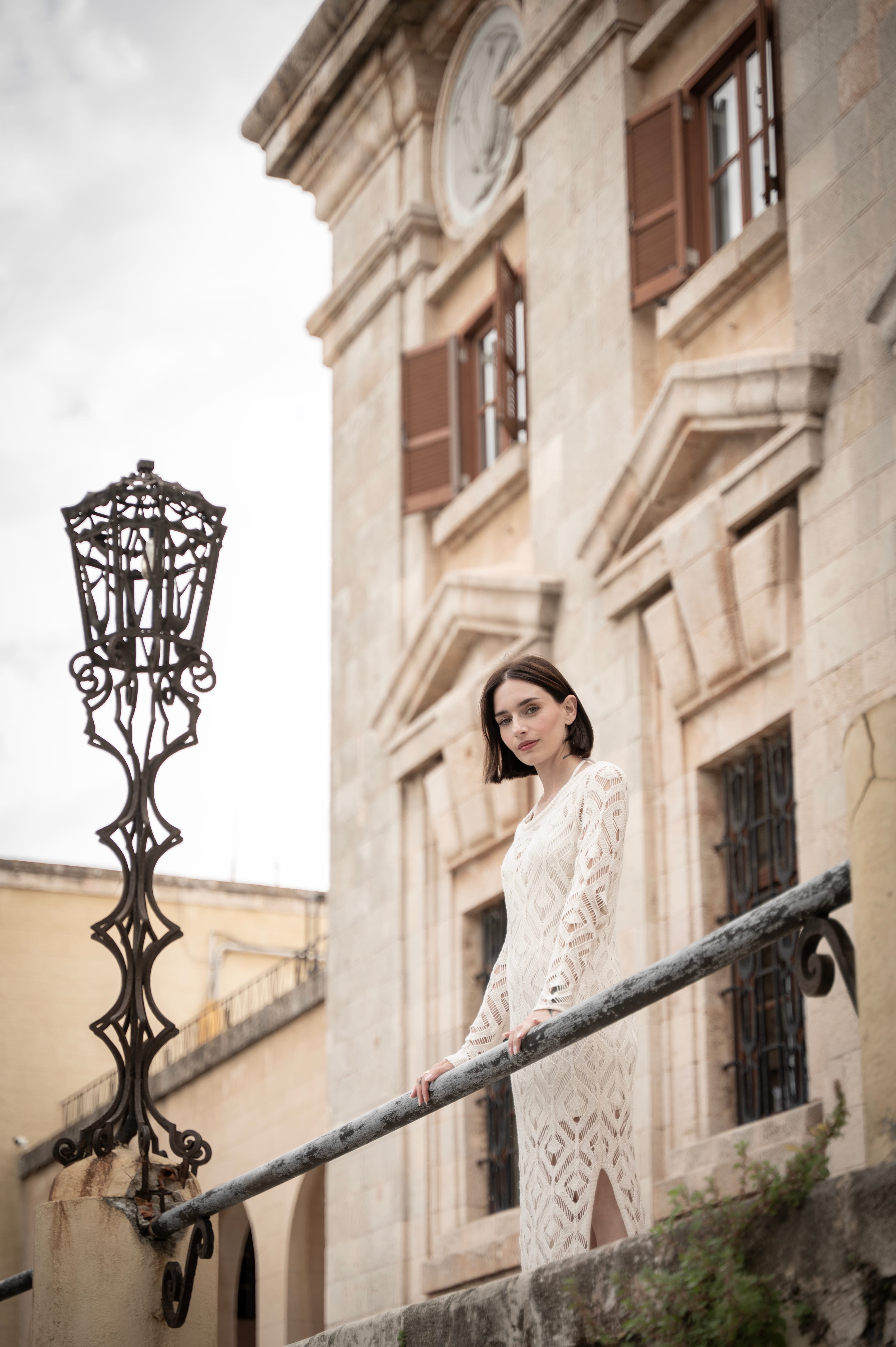 a person in a white dress standing on a balcony