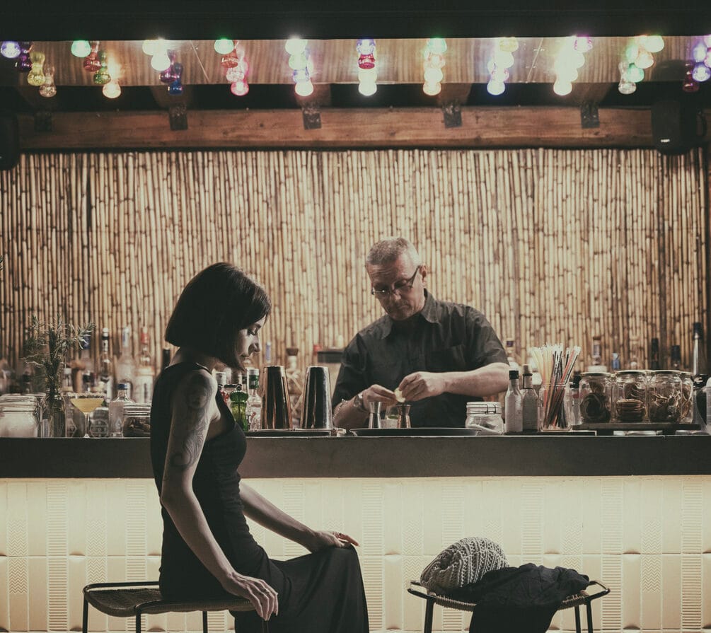a man and woman sitting at a bar