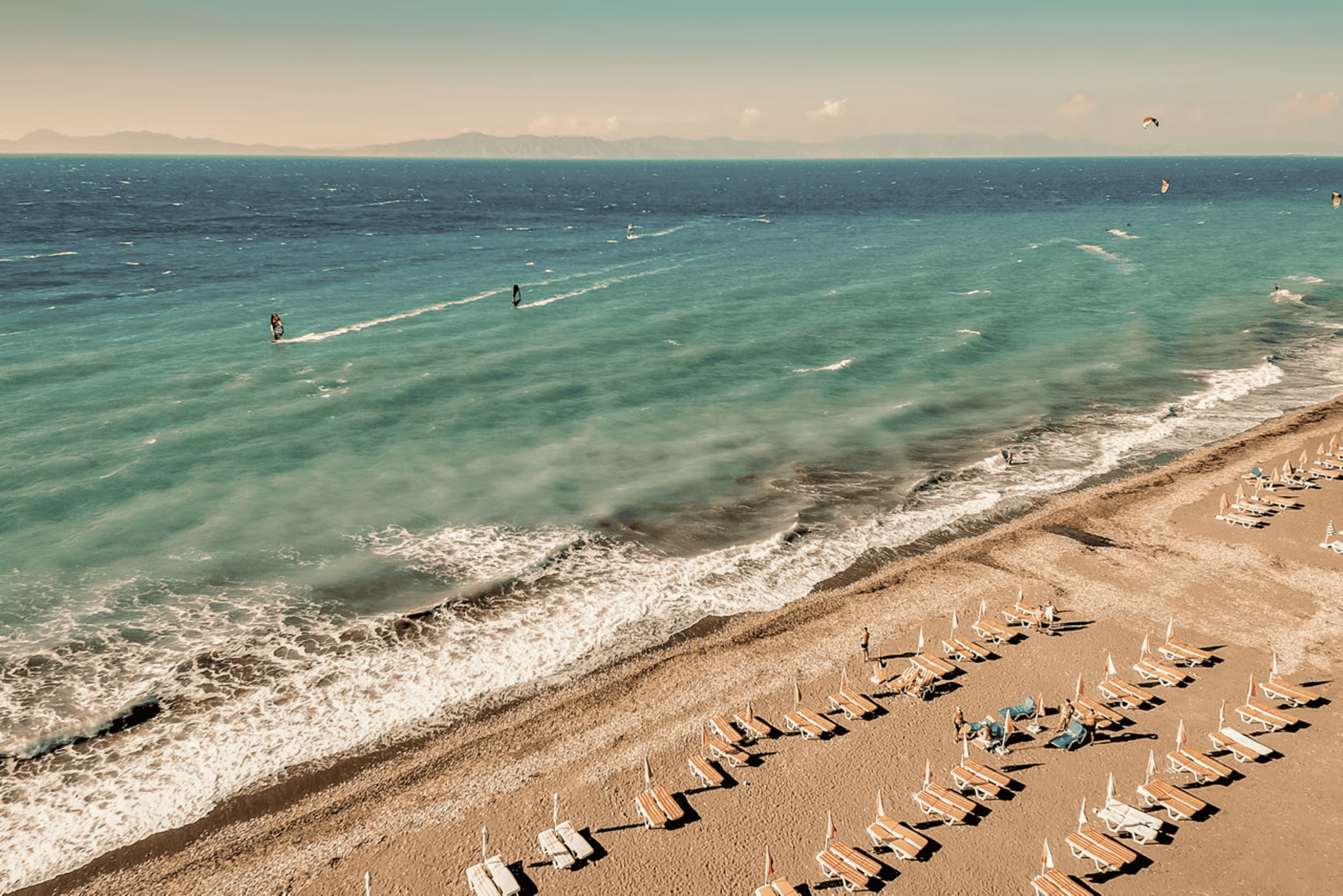 a beach with people and umbrellas