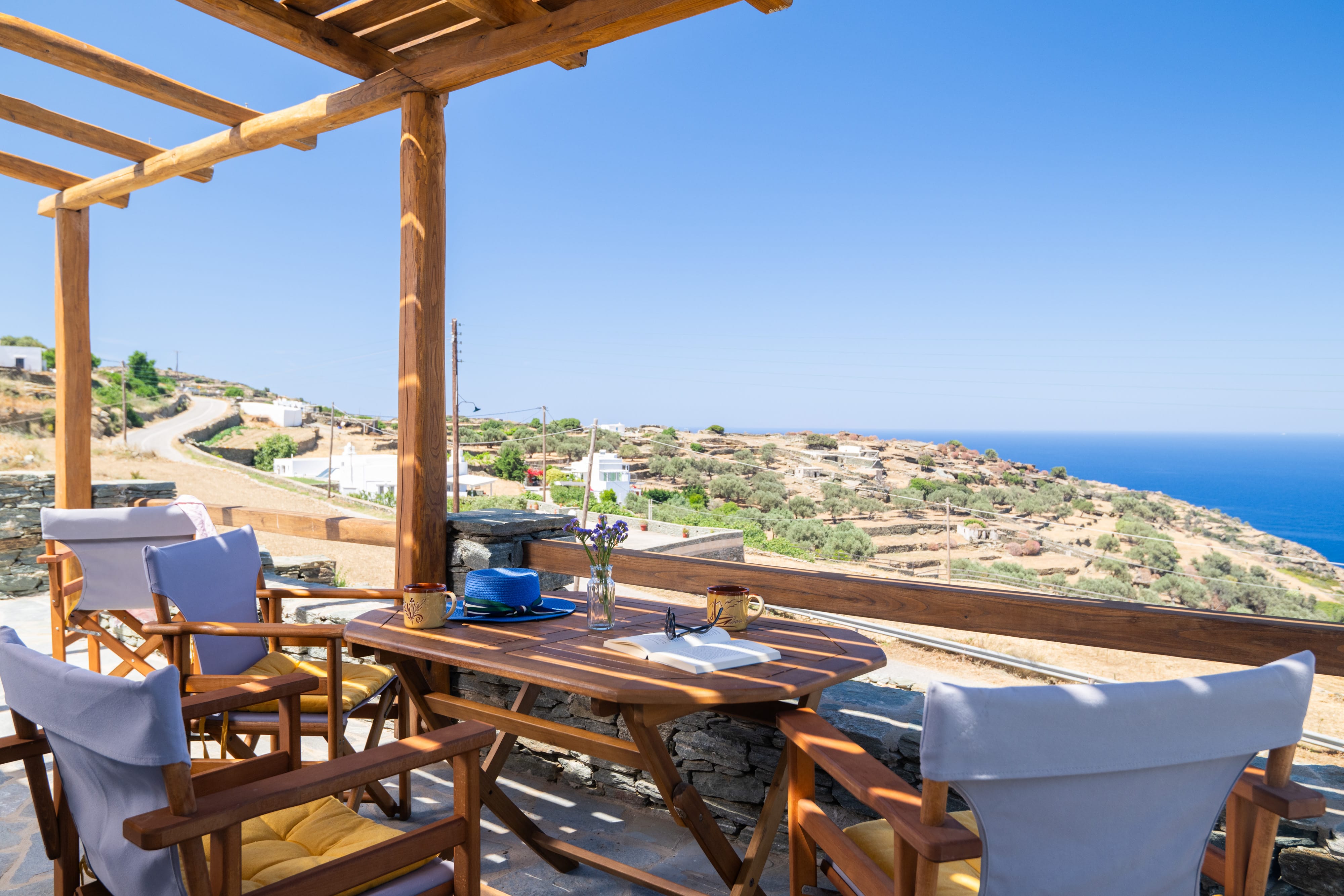 a table and chairs on a deck overlooking the ocean