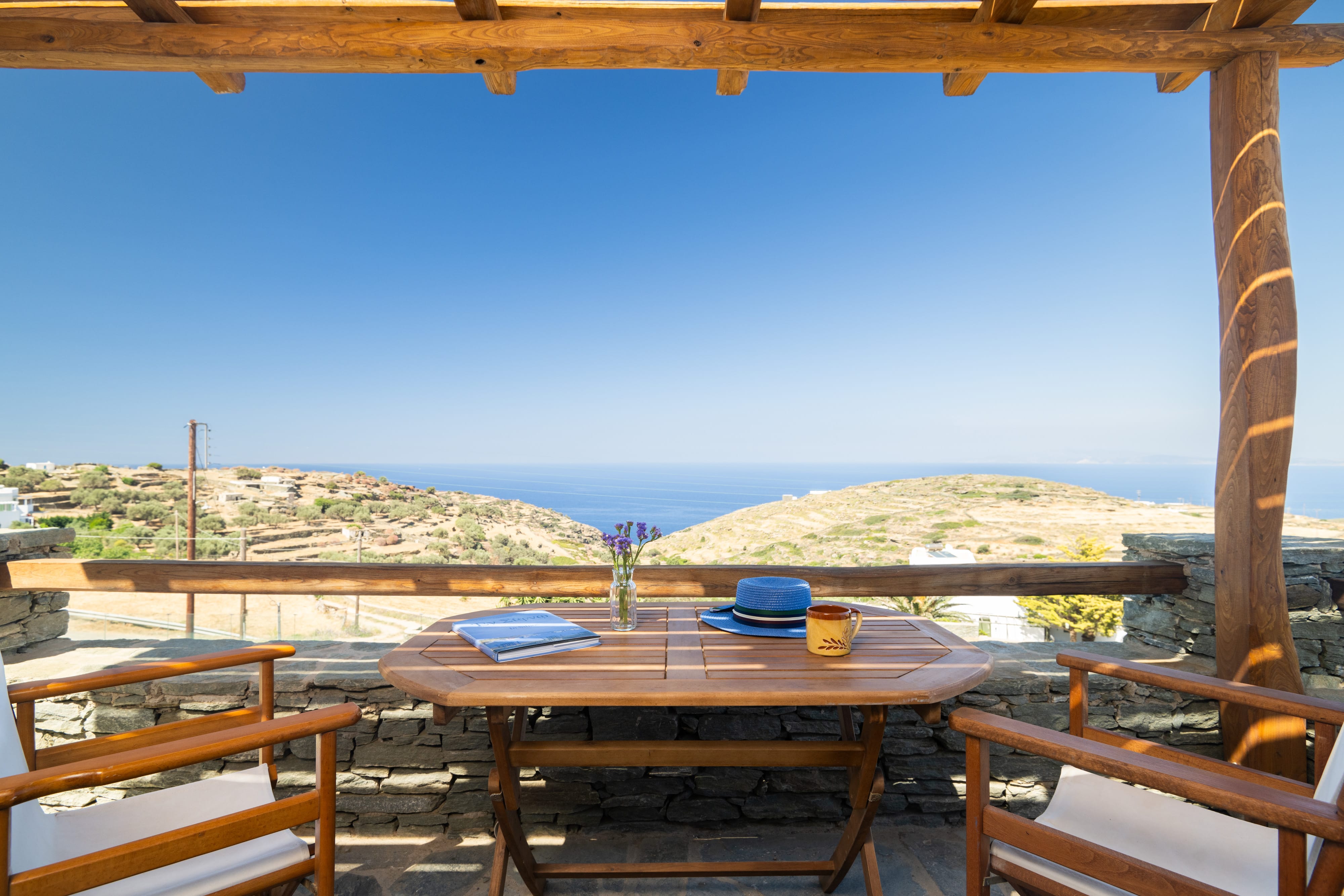 a table and chairs on a patio overlooking the ocean