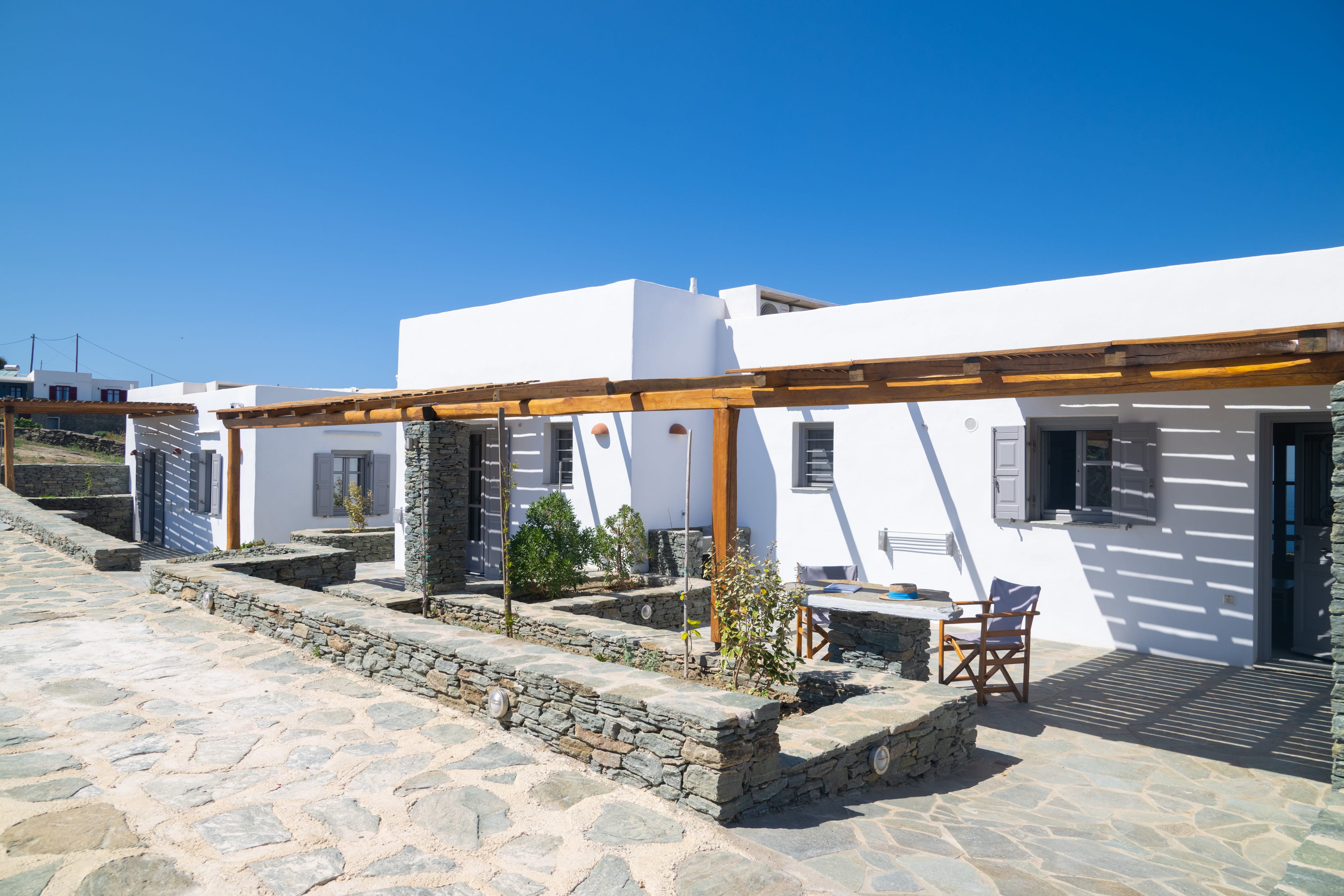 a white house with stone walls and a stone patio