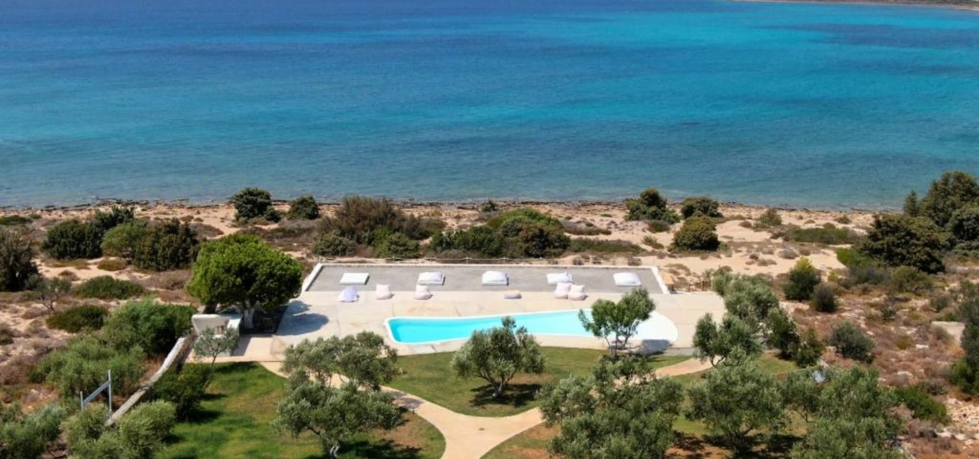 a beach with trees and a pool