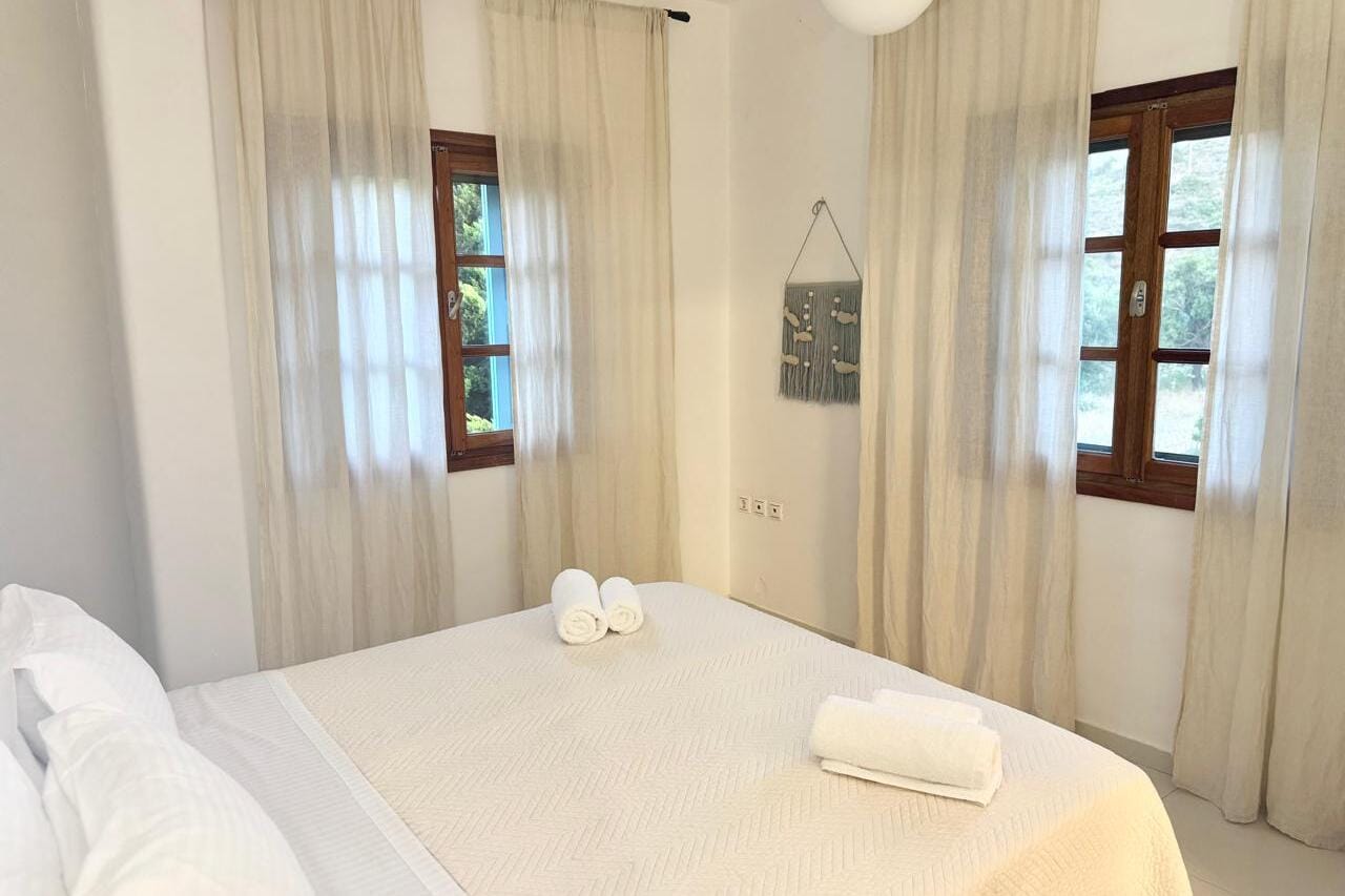a bed with white sheets and towels