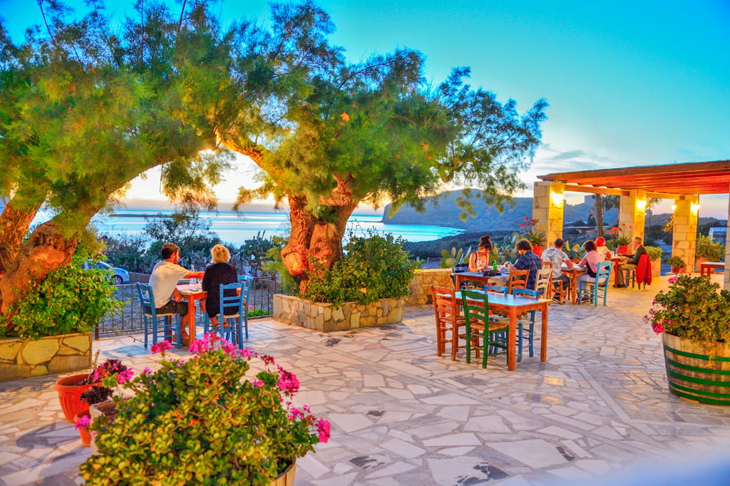a group of people sitting at a table outside