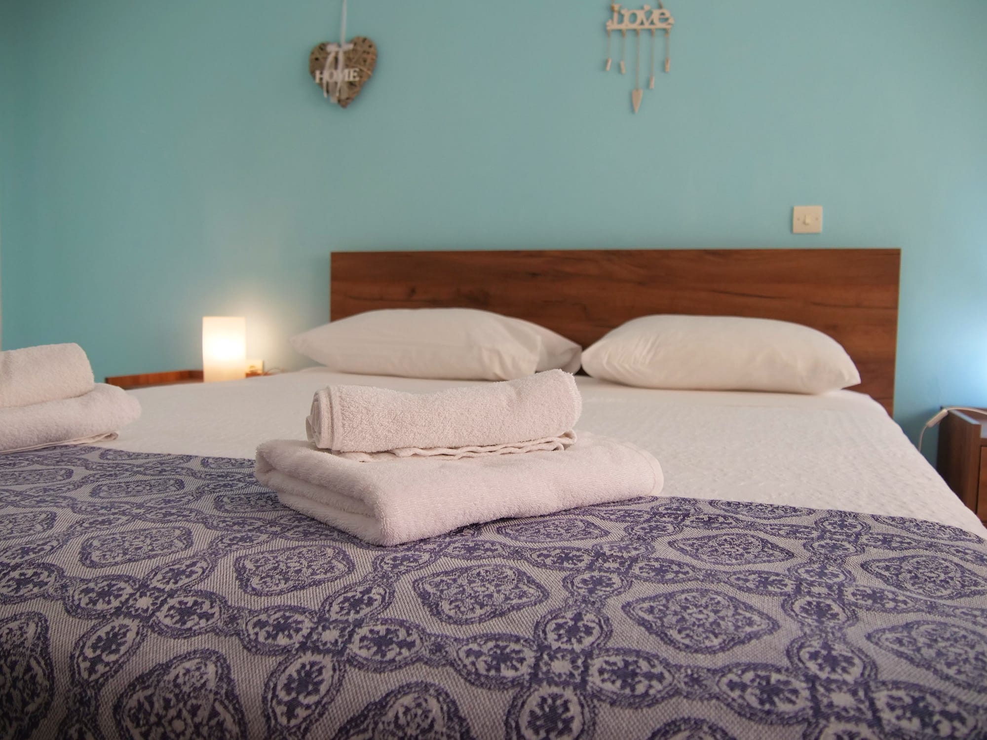 a bed with white pillows and towels