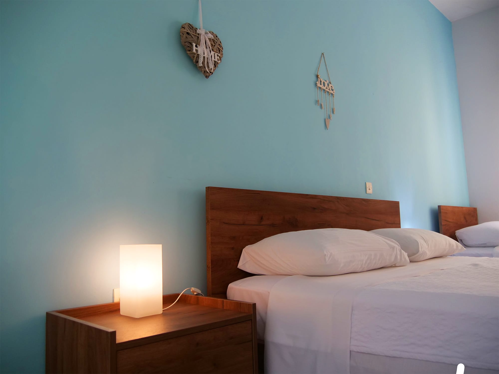 a bed with a white sheet and a lamp on a nightstand