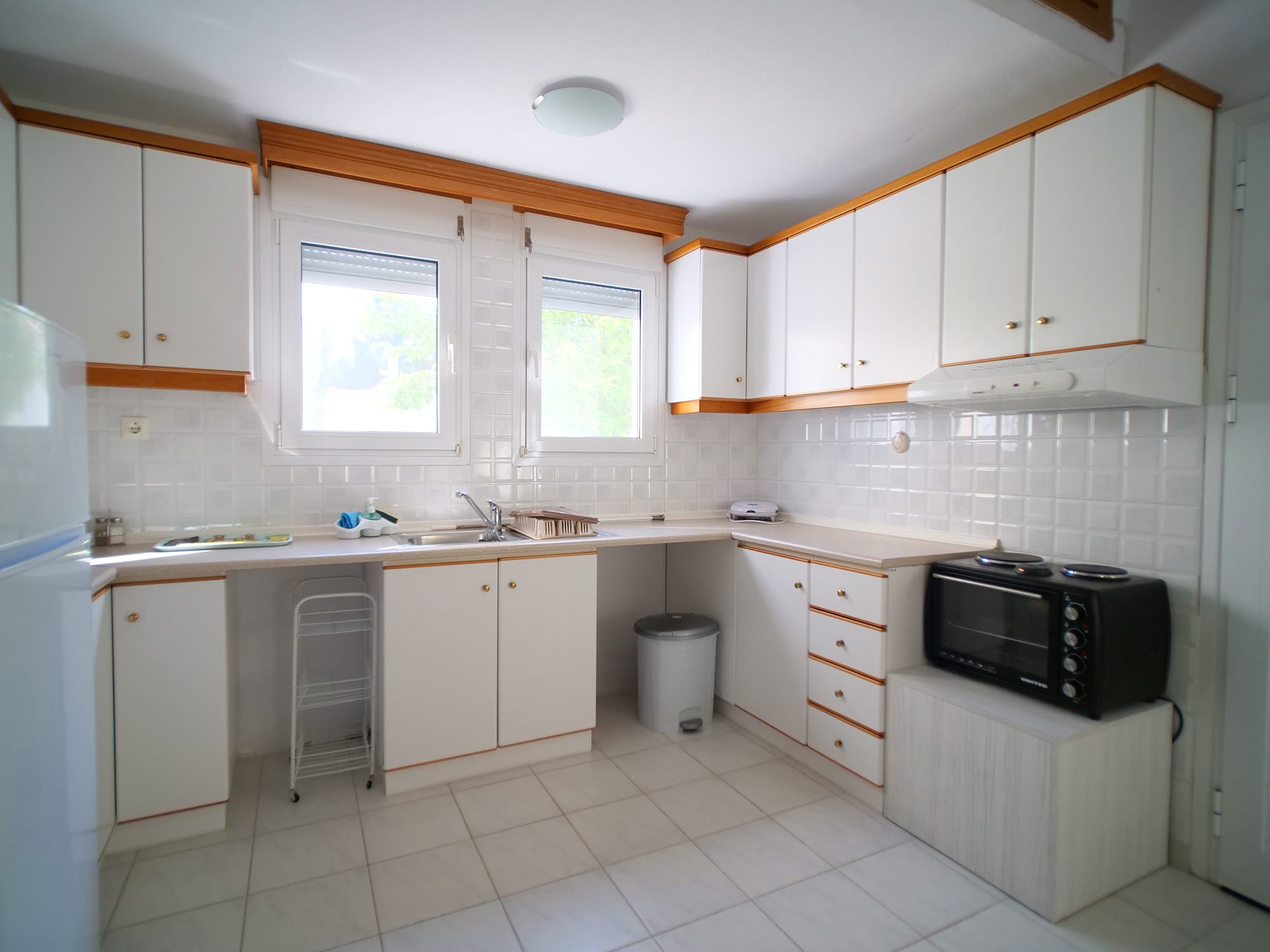 a kitchen with white cabinets and white countertops