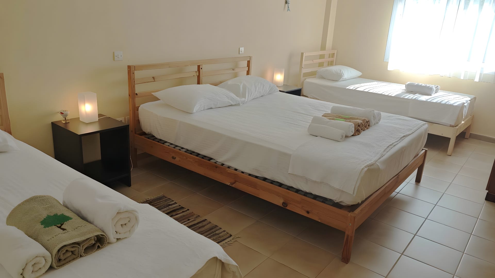 a bed with white sheets and towels