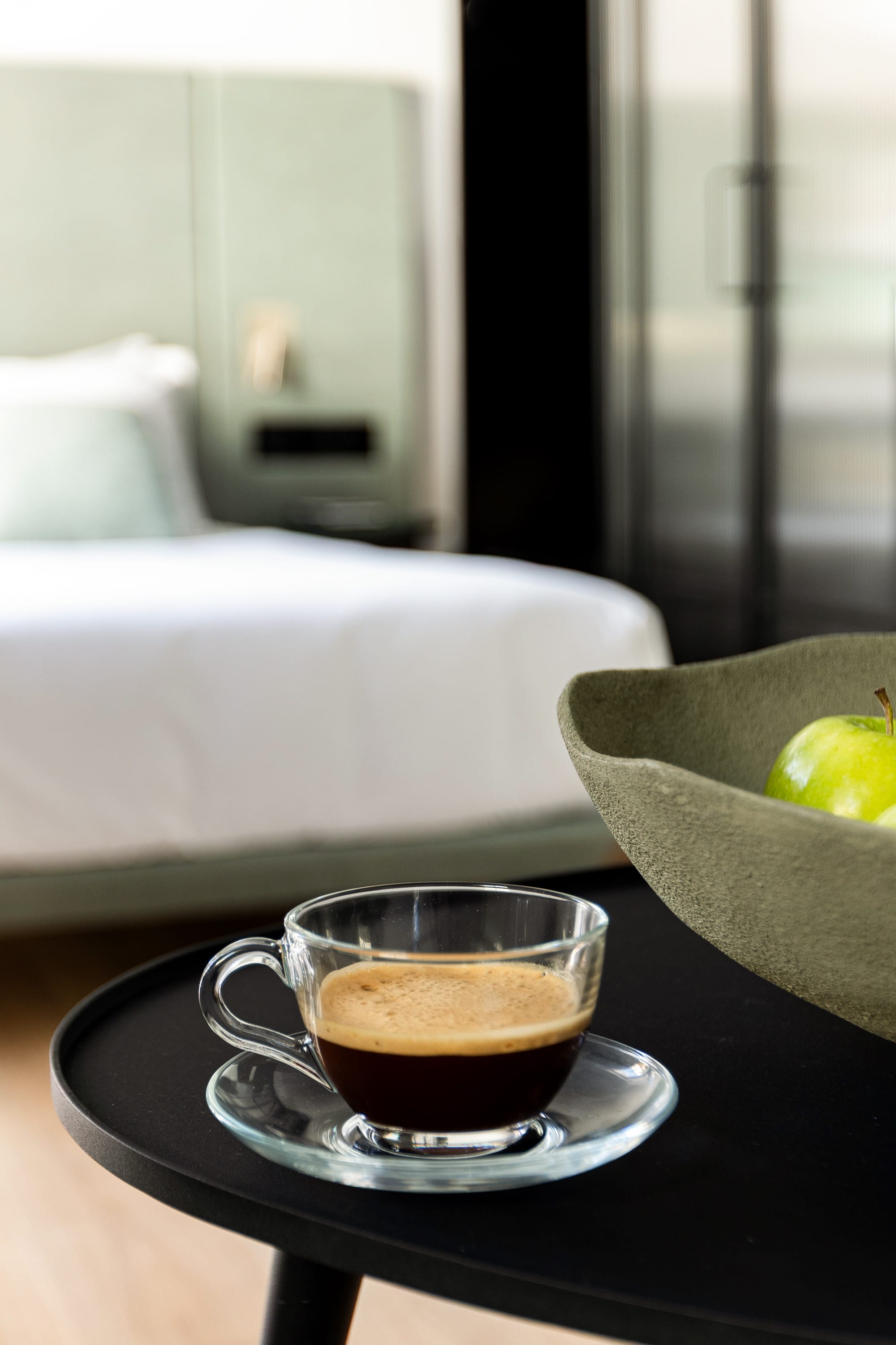 a cup of tea on a saucer next to a green apple