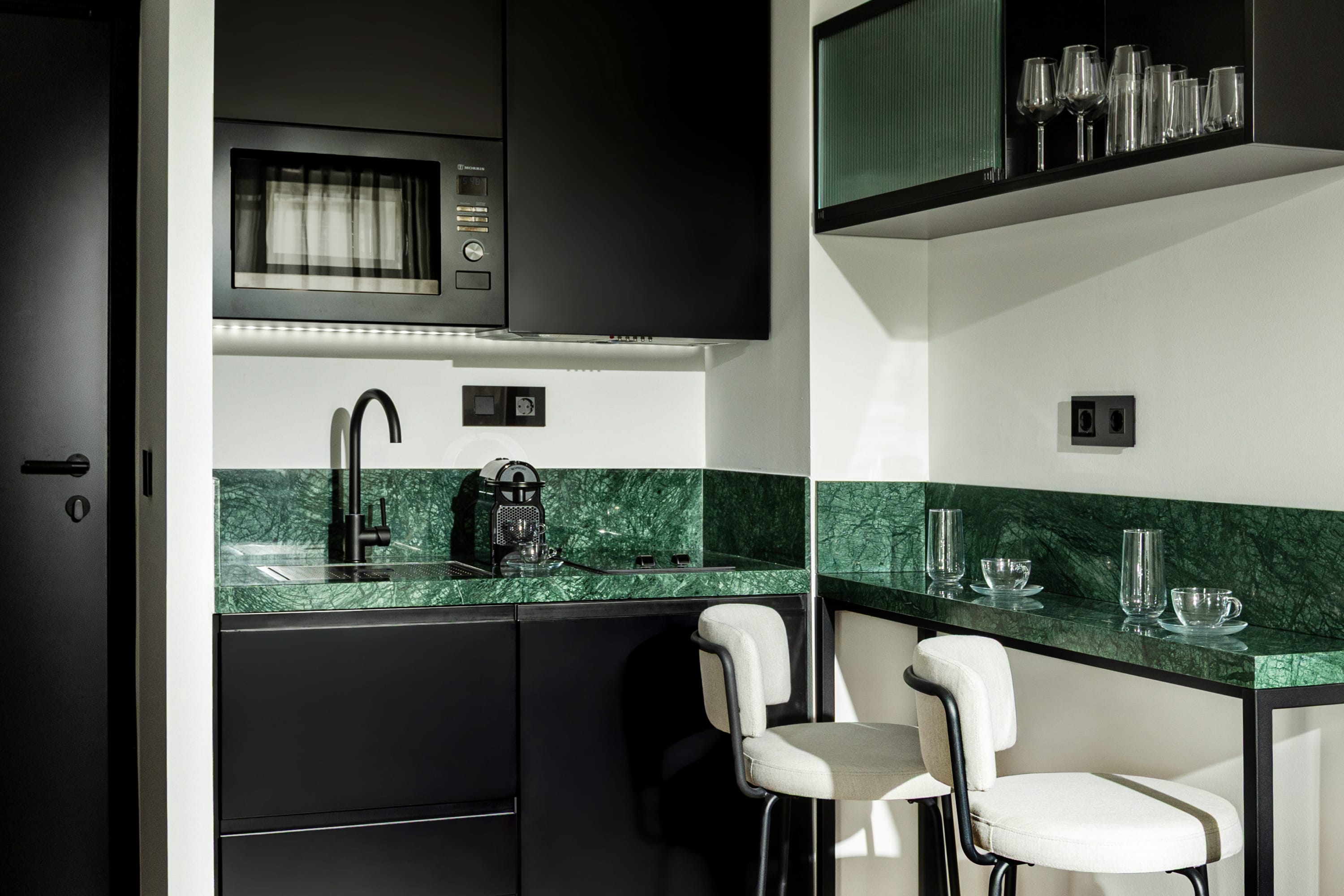 a kitchen with a bar and chairs
