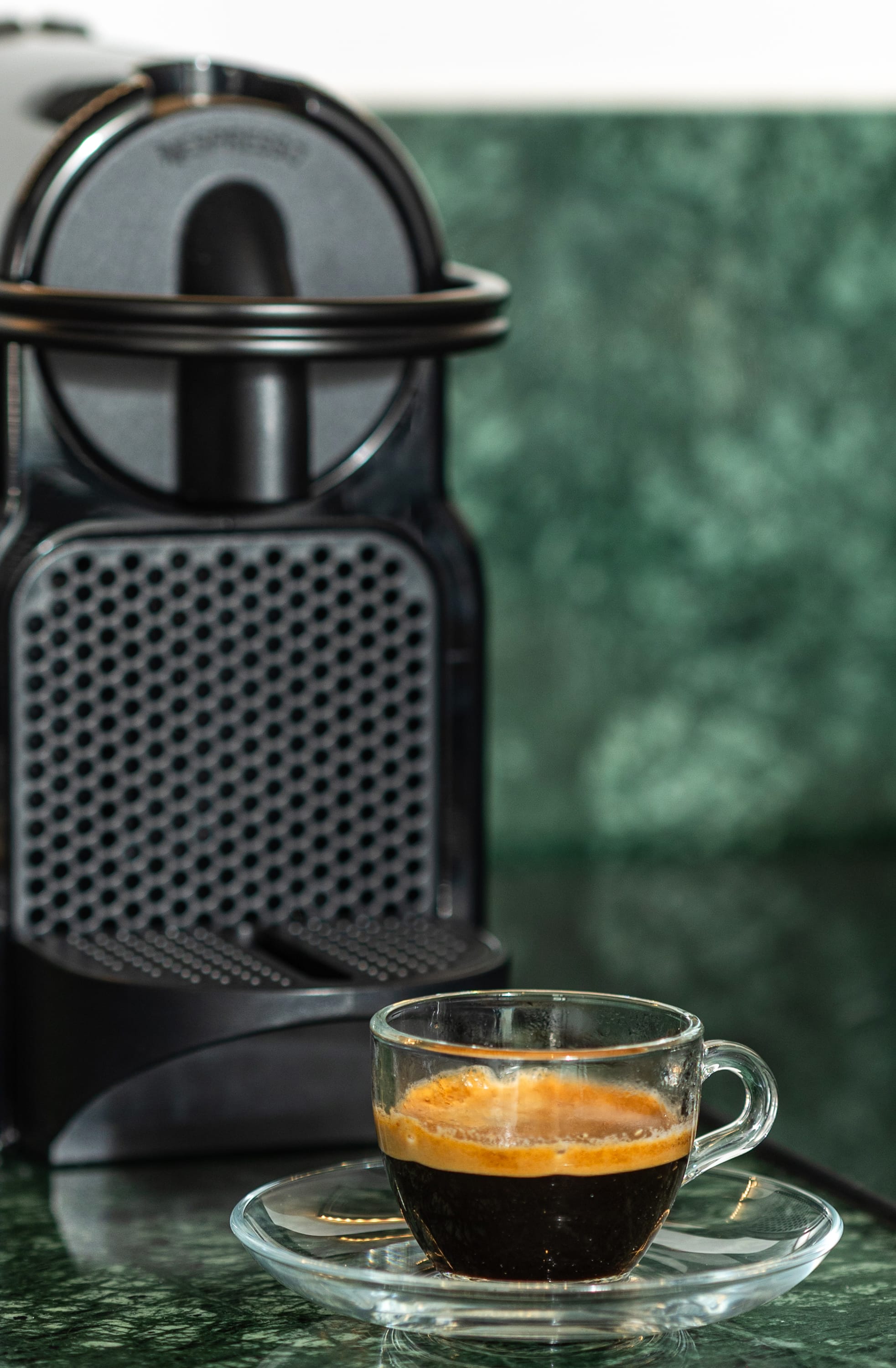 a glass of tea next to a tea kettle and a glass of tea