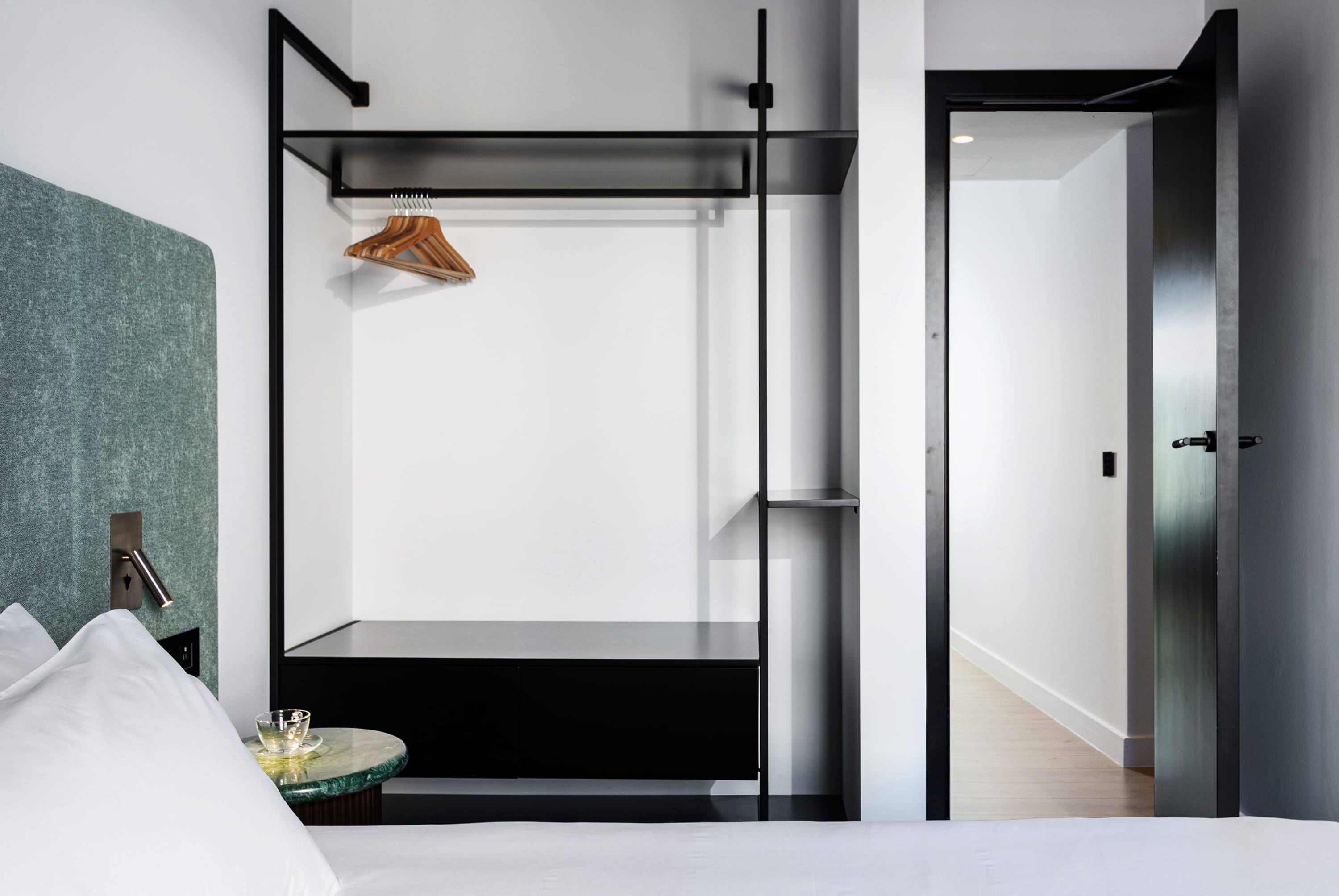 a room with a black shelf and white doors